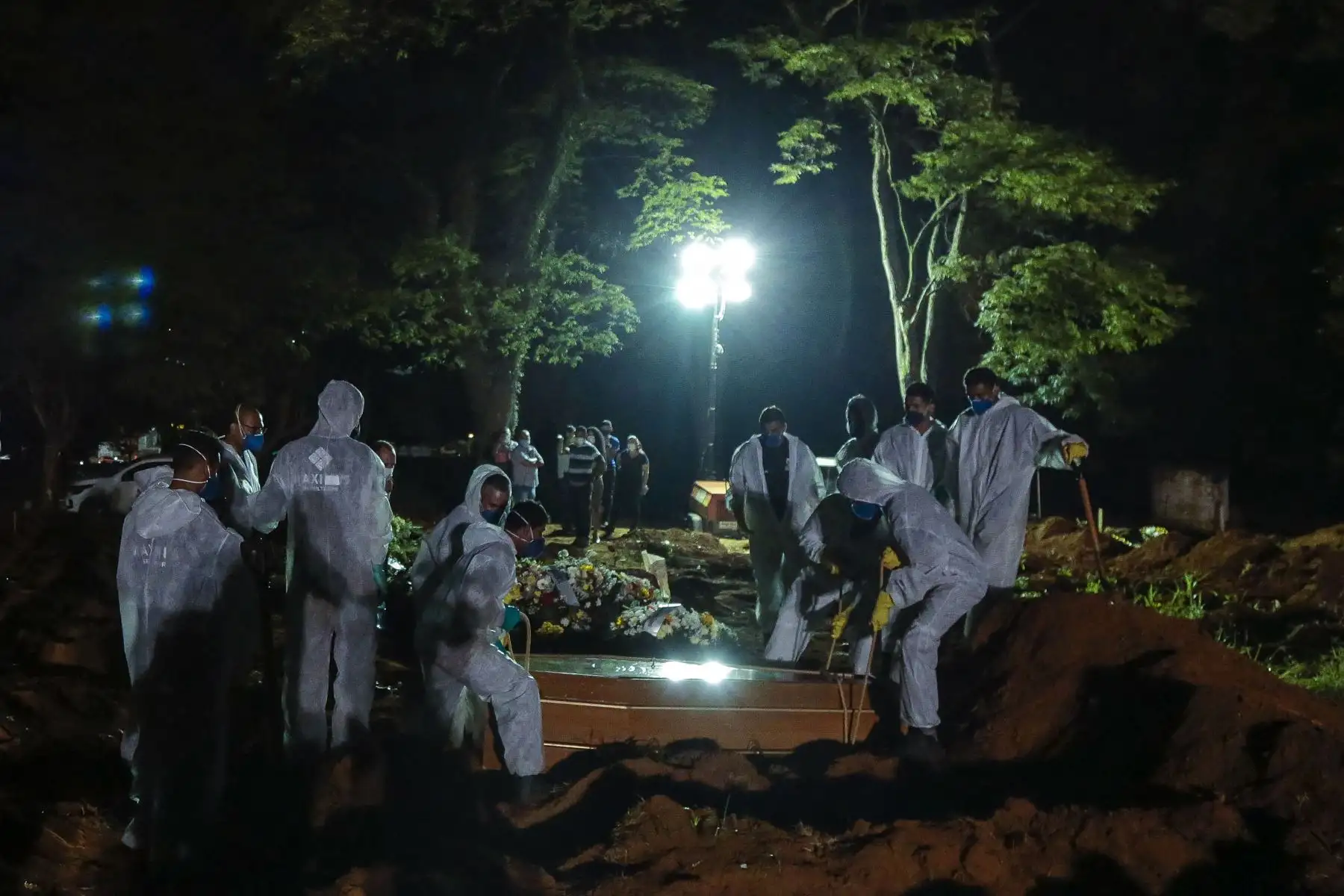 Los trabajadores del cementerio llevan un ataúd durante el primer entierro en la noche en medio de la pandemia de coronavirus, en el cementerio de Vila Formosa en Sao Paulo, Brasil, el 25 de marzo de 2021. Foto: AFP