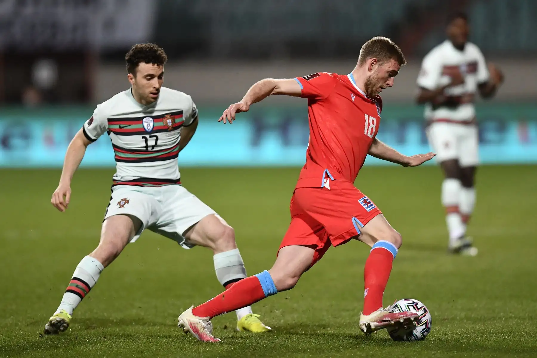 El delantero portugués Diogo Jota pelea por el balón con el defensa luxemburgués Laurent Jans durante el partido de clasificación del Grupo A para la Copa Mundial de la FIFA Qatar 2022. Foto: AFP