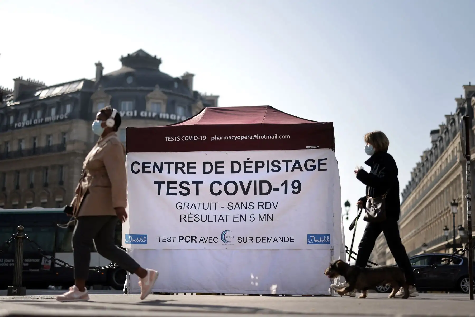 La gente pasa frente a una carpa donde los pacientes se someten a una prueba de antígeno covid-19, en la plaza de la Ópera de París, el 31 de marzo de 2021. Foto: AFP