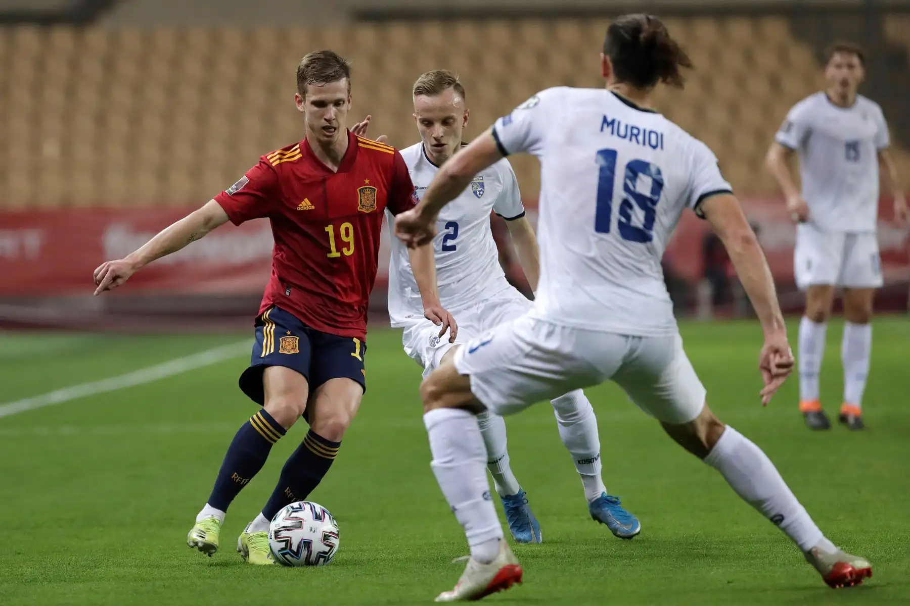 El centrocampista de España Dani Olmo controla el balón ante los jugadores de Kosovo Florent Hadergjonaj y Vedat Muriqi en el partido de clasificación para el Mundial Catar 2022. Foto: EFE