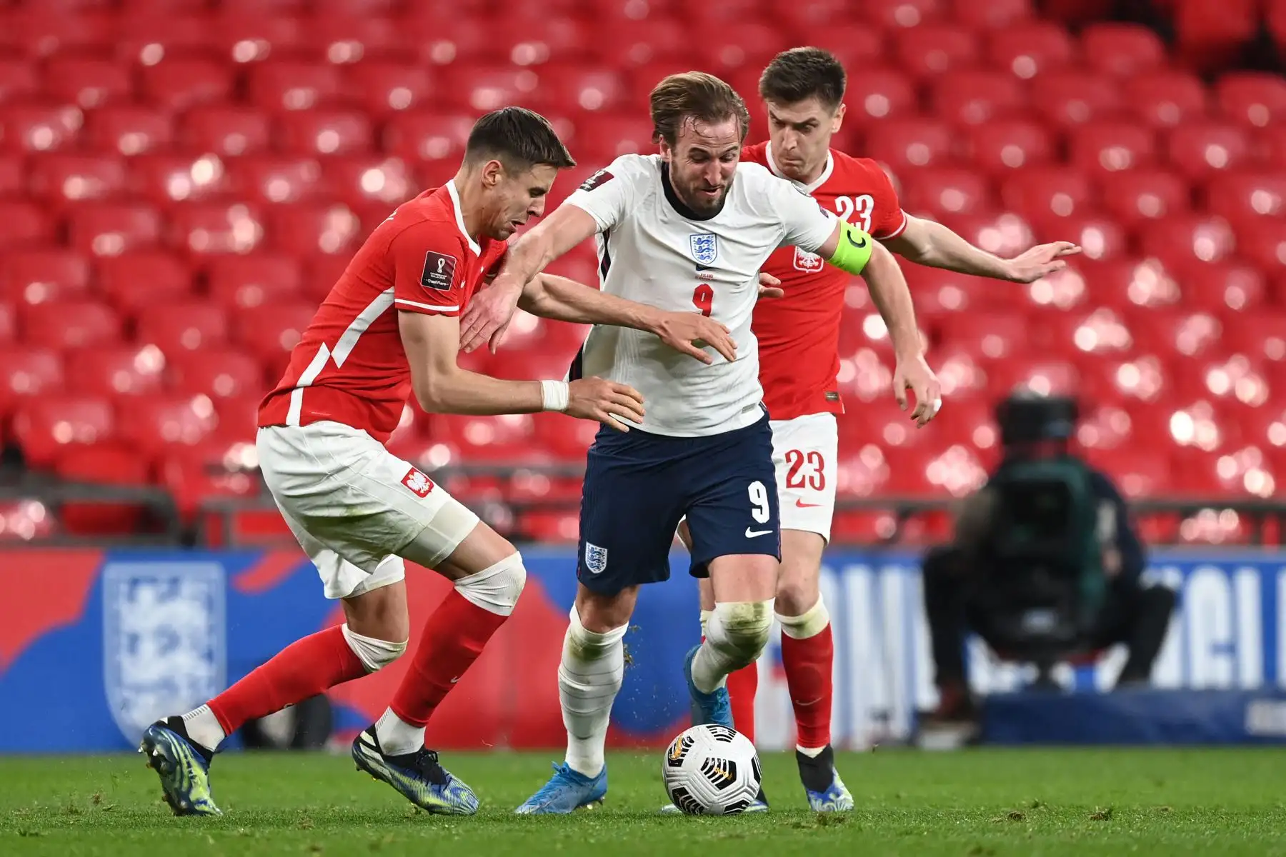 El delantero de Inglaterra Harry Kane se enfrenta al defensor de Polonia Jan Bednarek y al delantero de Polonia Krzysztof Piatek durante el partido de clasificación de la Copa Mundial de la FIFA Qatar 2022. Foto: AFP