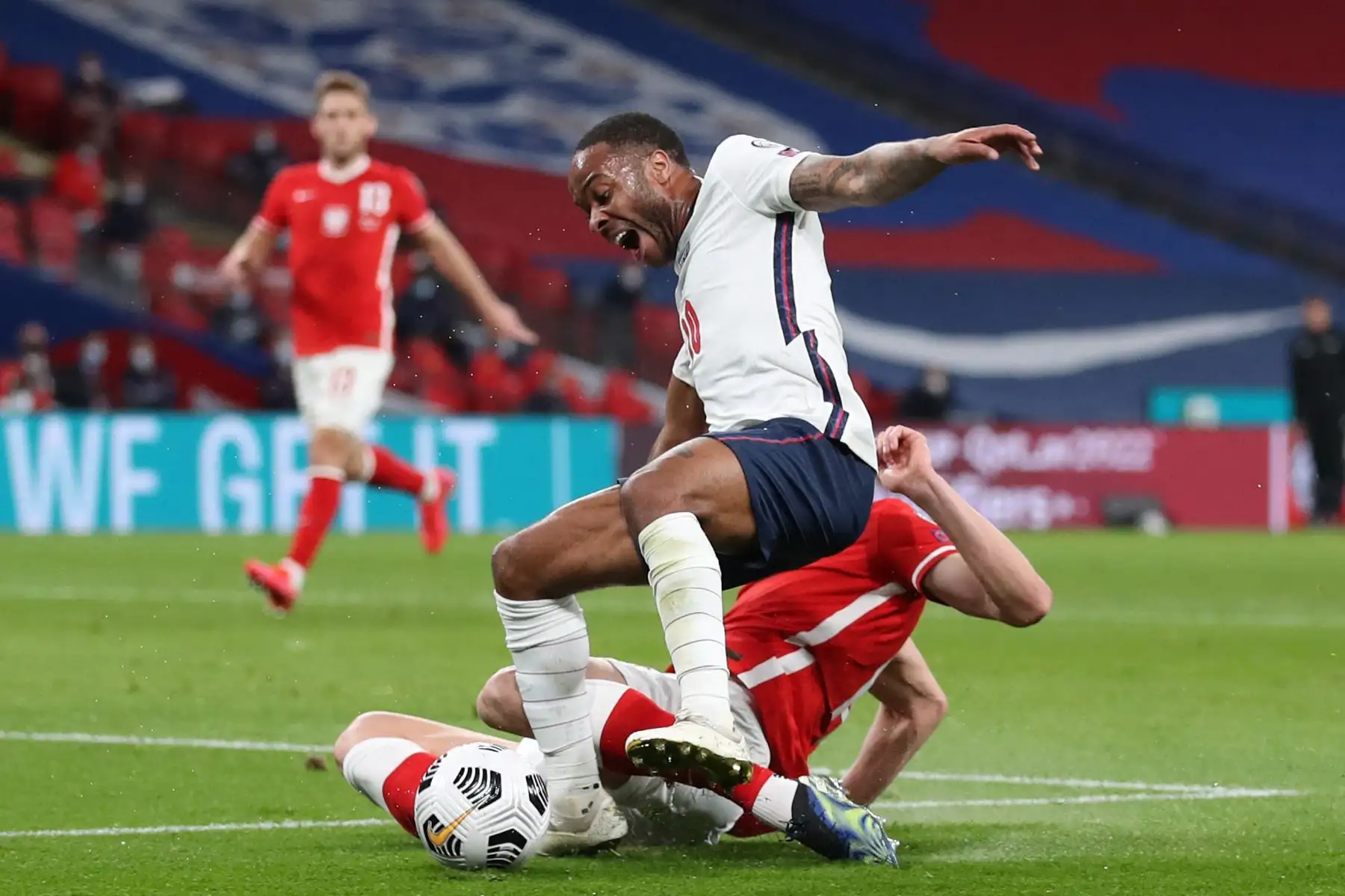 El defensor de Polonia Michal Helik comete una falta contra el centrocampista de Inglaterra Raheem Sterling para conceder un penalti que conduce al primer gol durante el partido de clasificación del Grupo I de la Copa Mundial de la FIFA Qatar 2022. Foto: AFP
