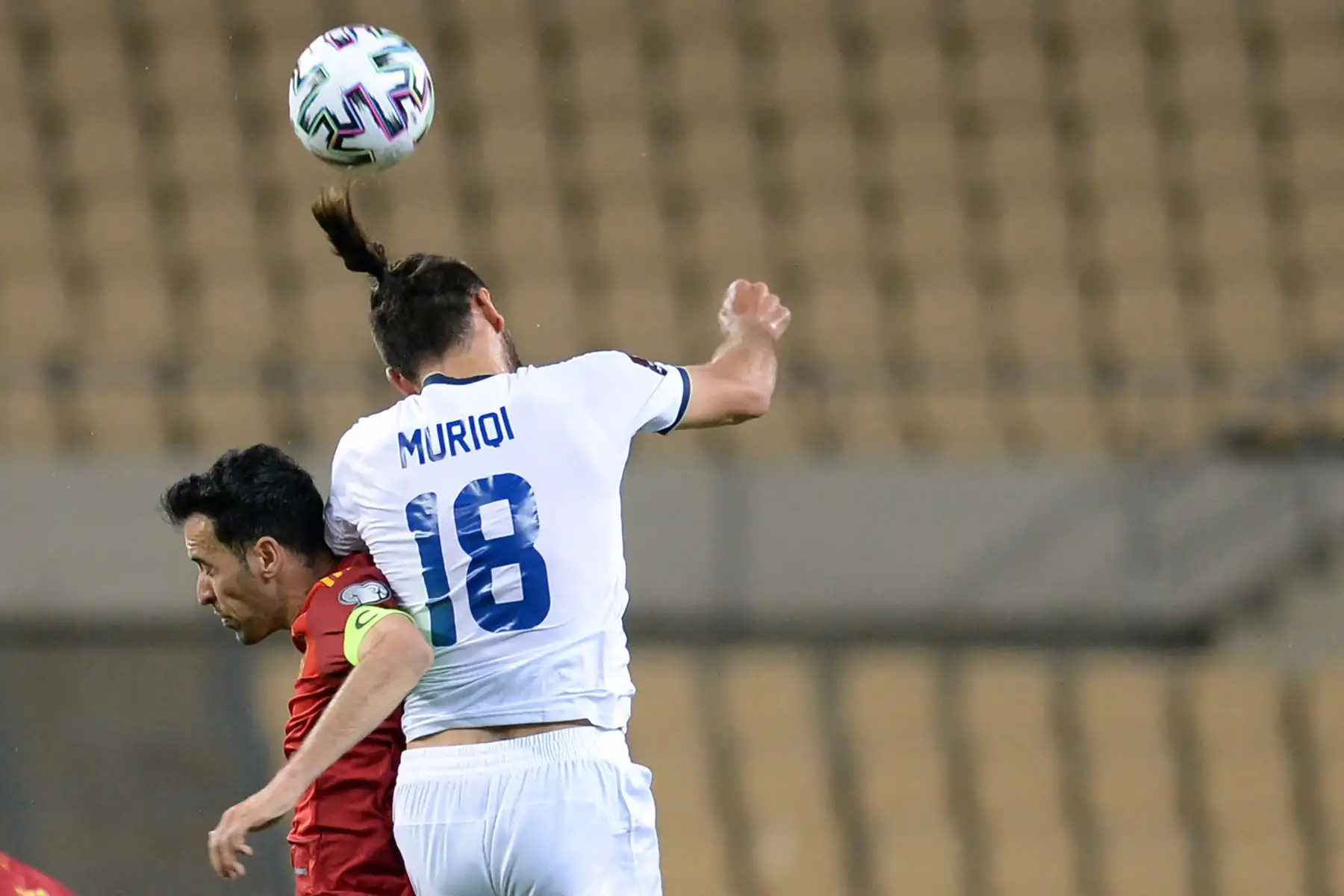El centrocampista español Sergio Busquets salta por el balón con el delantero de Kosovo Vedat Muriqi durante el partido de clasificación de la Copa Mundial de la FIFA Qatar 2022. Foto: AFP