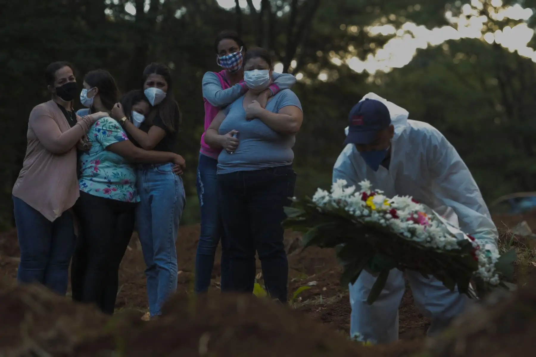 Familiares de una víctima del covid-19 lloran mientras su ser querido es enterrado en el cementerio de Vila Formosa en Sao Paulo Brasil. Foto: AFP