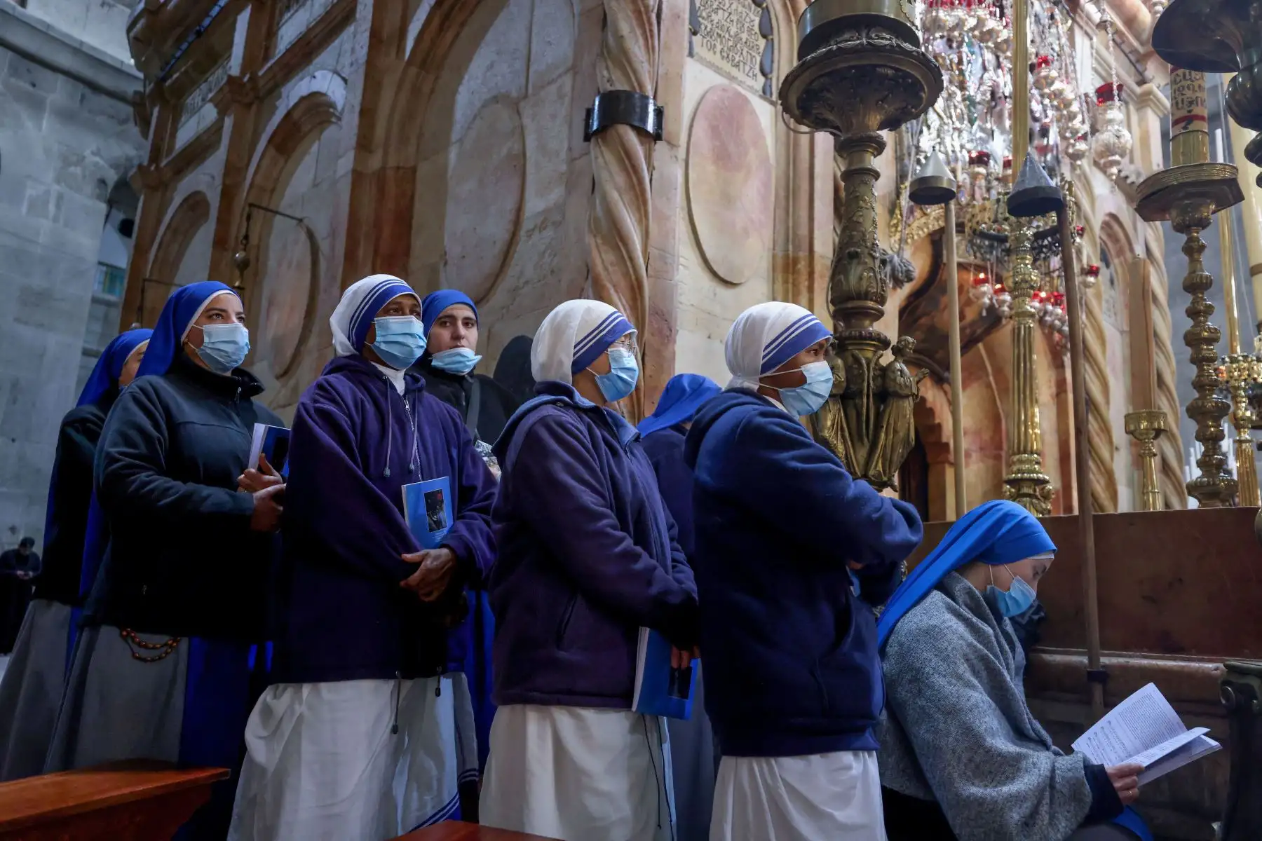 Monjas católicas asisten a una misa para conmemorar el Lavatorio de los pies alrededor del Edículo, tradicionalmente considerado el lugar de enterramiento de Jesucristo, el Jueves Santo en la Iglesia del Santo Sepulcro en Jerusalén,. Foto: AFP