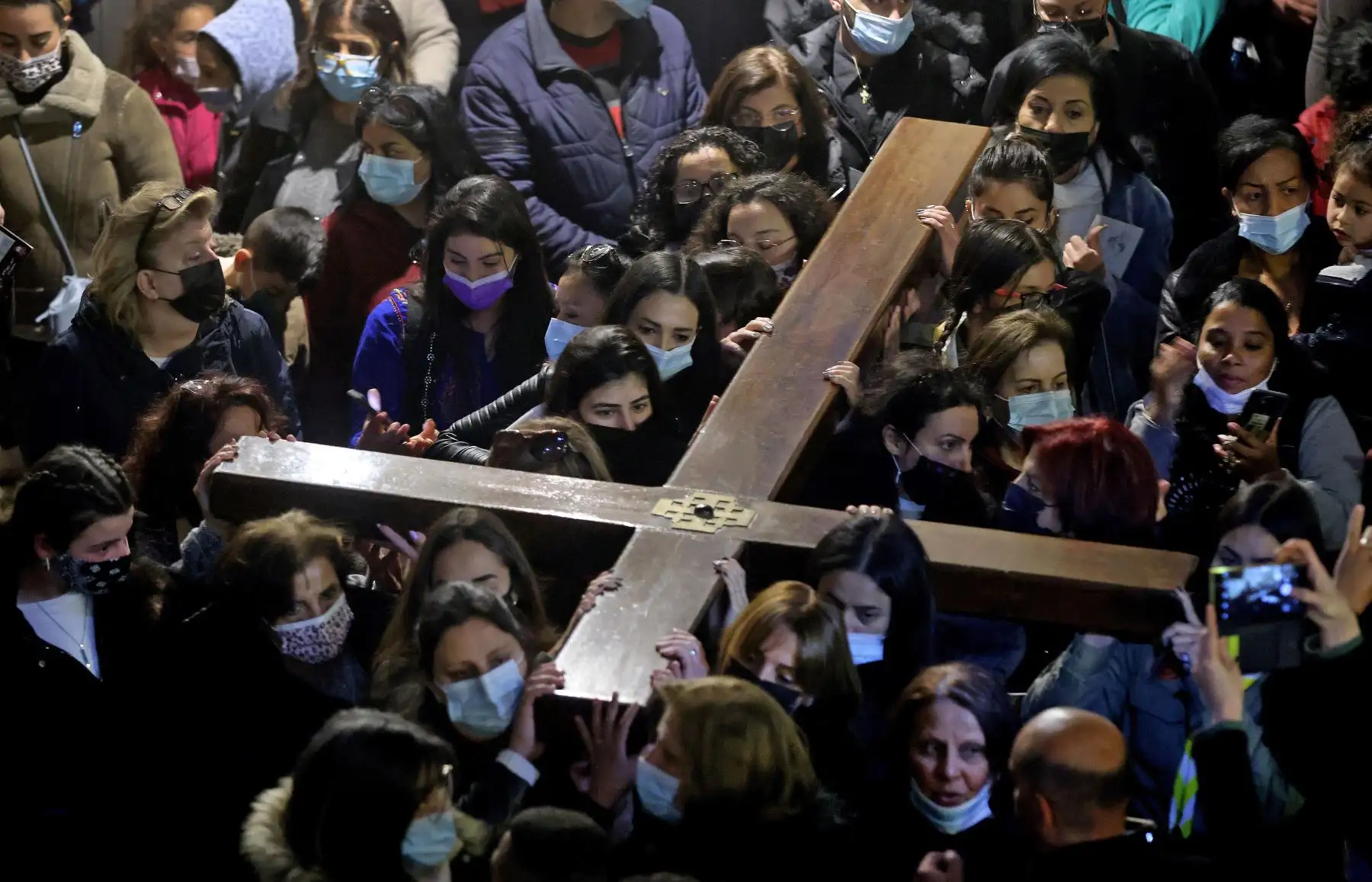 Fieles cristianos llevan una cruz de madera a lo largo de la Vía Dolorosa, Camino del Sufrimiento en la Ciudad Vieja de Jerusalén durante la procesión del Viernes Santo. Foto: AFP
