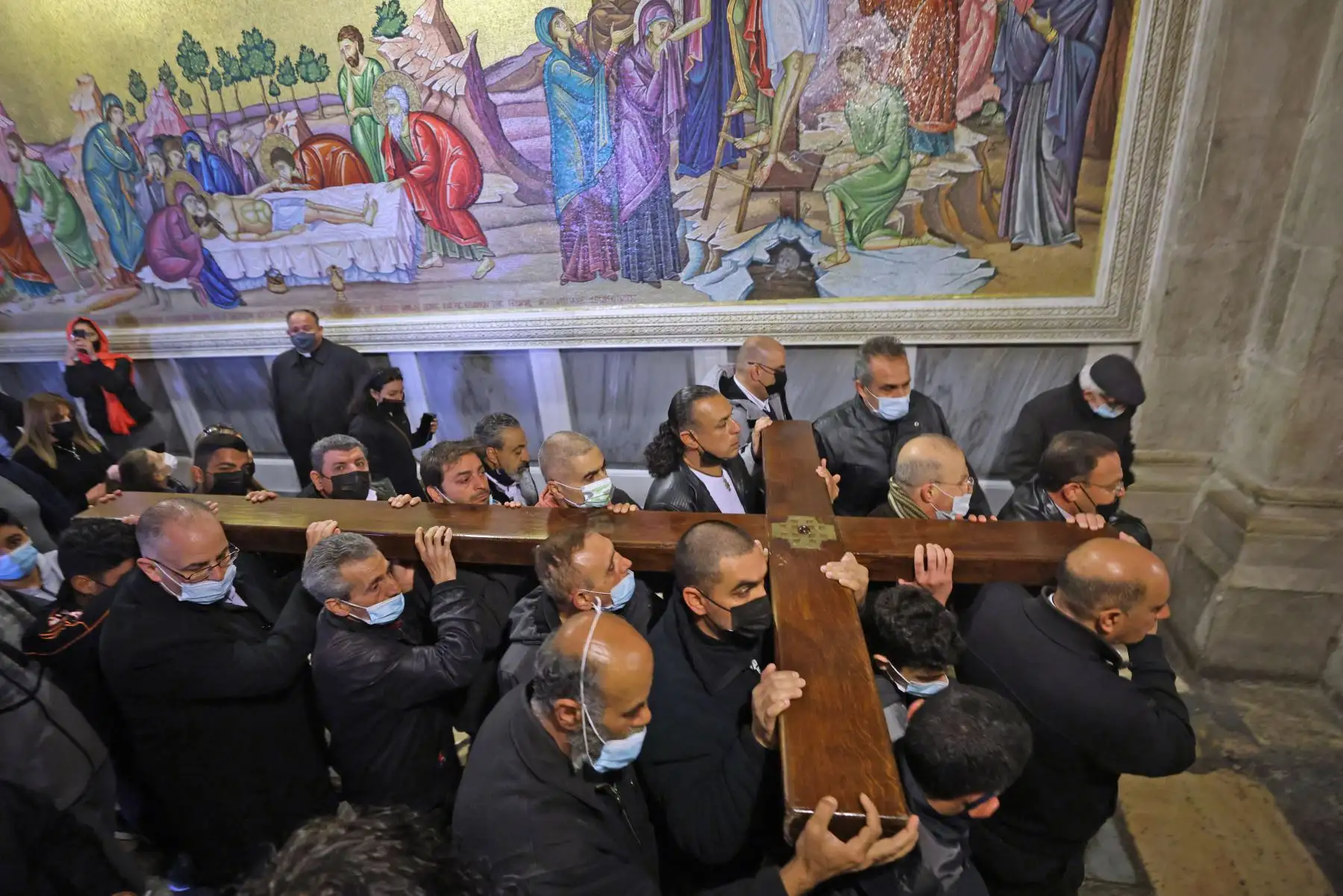 Fieles cristianos llevan una cruz de madera a lo largo de la Vía Dolorosa, Camino del Sufrimiento en la Ciudad Vieja de Jerusalén durante la procesión del Viernes Santo. Foto: AFP