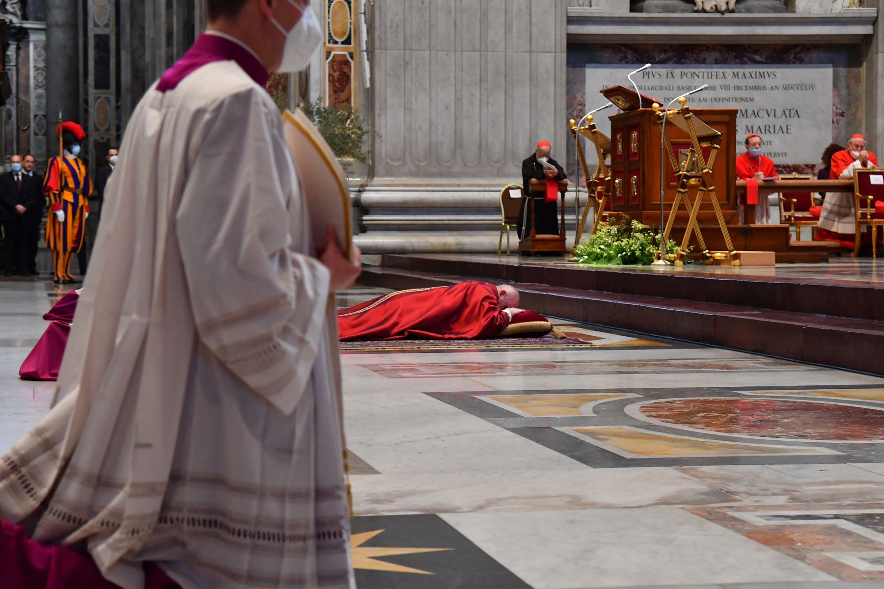 El Papa Francisco se recuesta en oración antes de celebrar la Misa del Viernes Santo en la Basílica de San Pedro en el Vaticano, durante la pandemia del coronavirus Covid-19. Foto: AFP