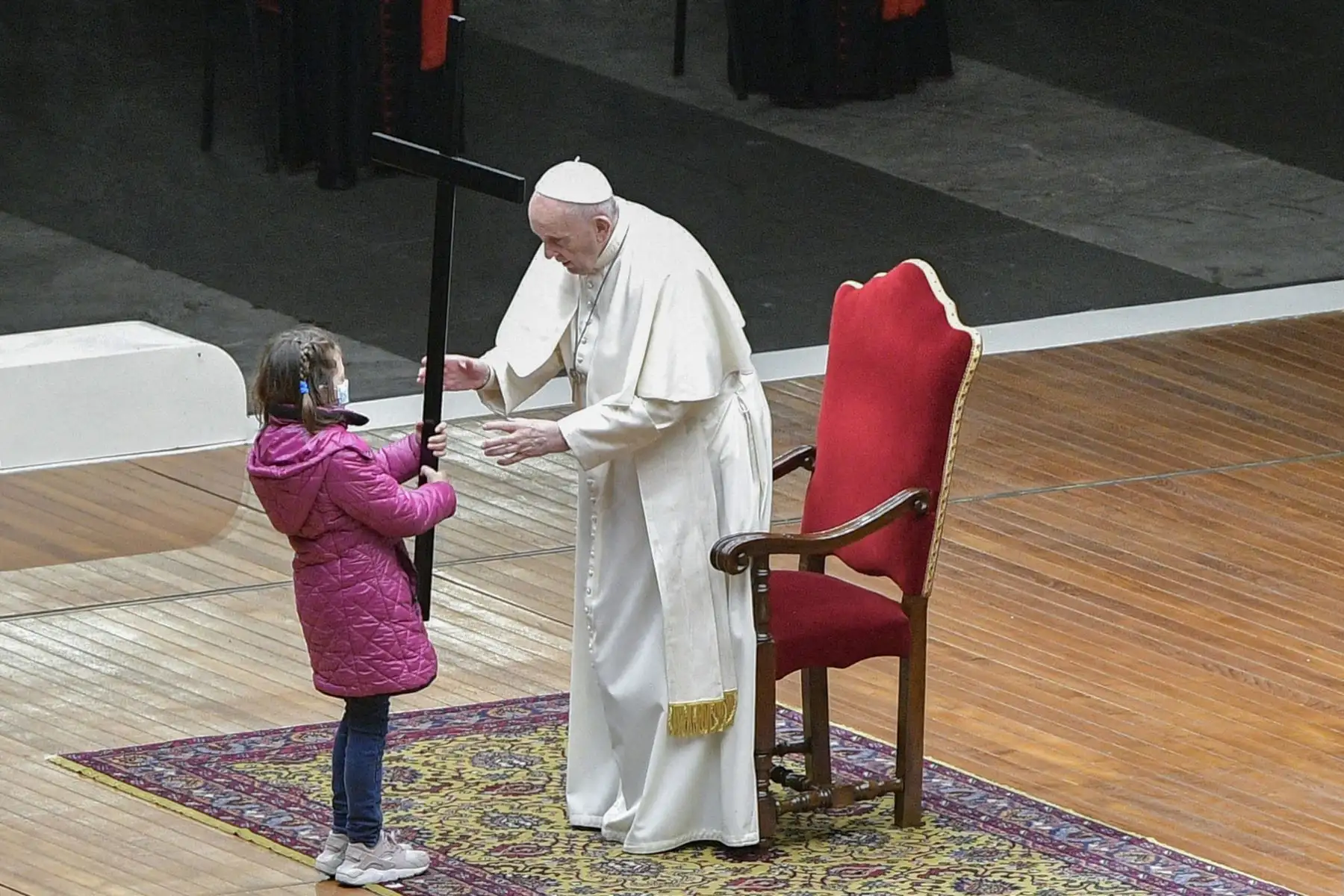 Una niña entrega la Cruz al Papa Francisco mientras dirige la celebración del Vía Crucis este Viernes Santo, en el Vaticano. Foto: AFP