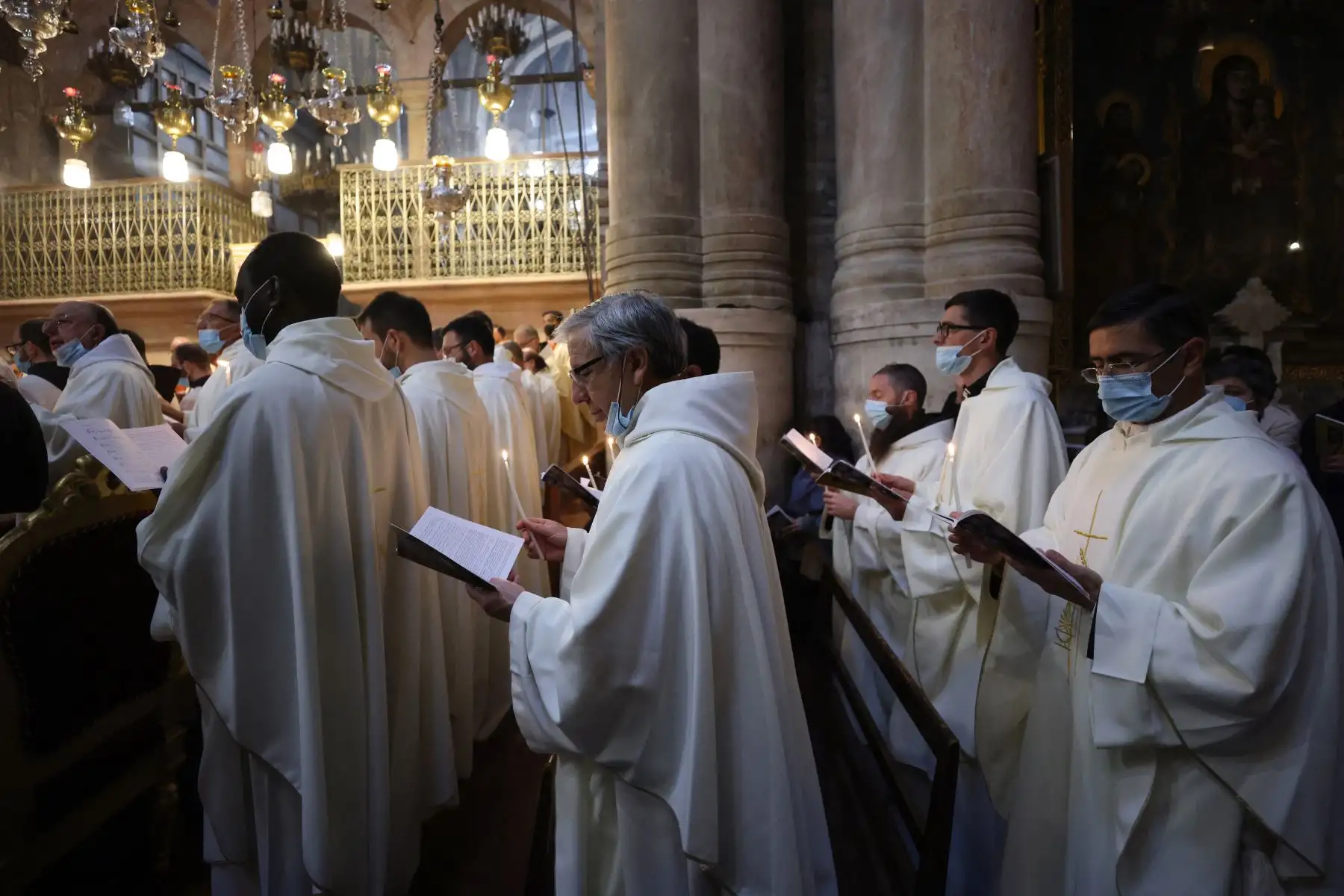 Los frailes franciscanos, con mascarillas debido a la pandemia de coronavirus, asisten a una misa de vigilia de Pascua el Sábado Santo, en la Iglesia del Santo Sepulcro en Jerusalén.
Foto: AFP
