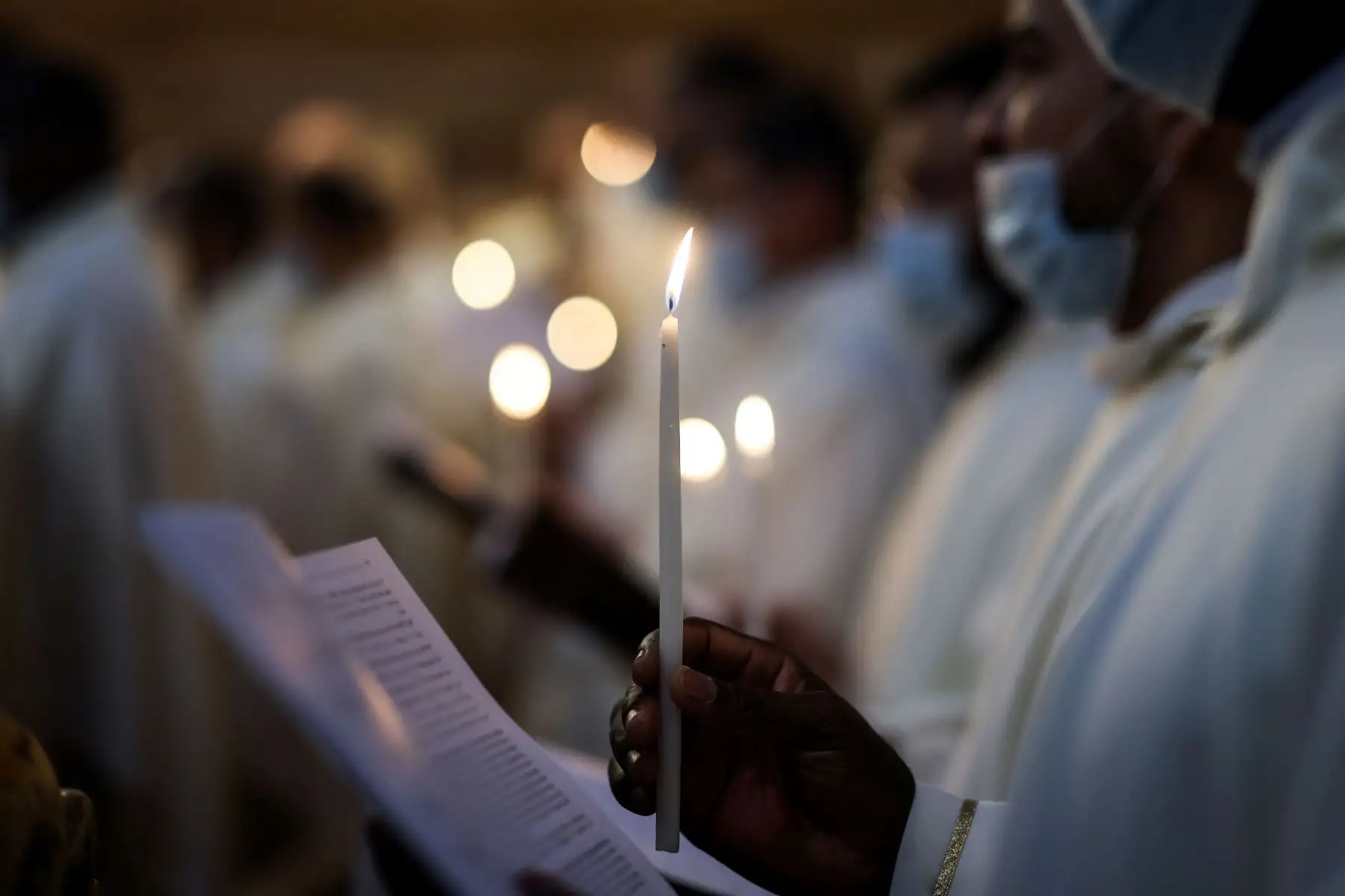 Los frailes franciscanos protegidos con mascarilla, debido a la pandemia de coronavirus, asisten a una misa de vigilia de Pascua el Sábado Santo, en la Iglesia del Santo Sepulcro en Jerusalén.
Foto: AFP