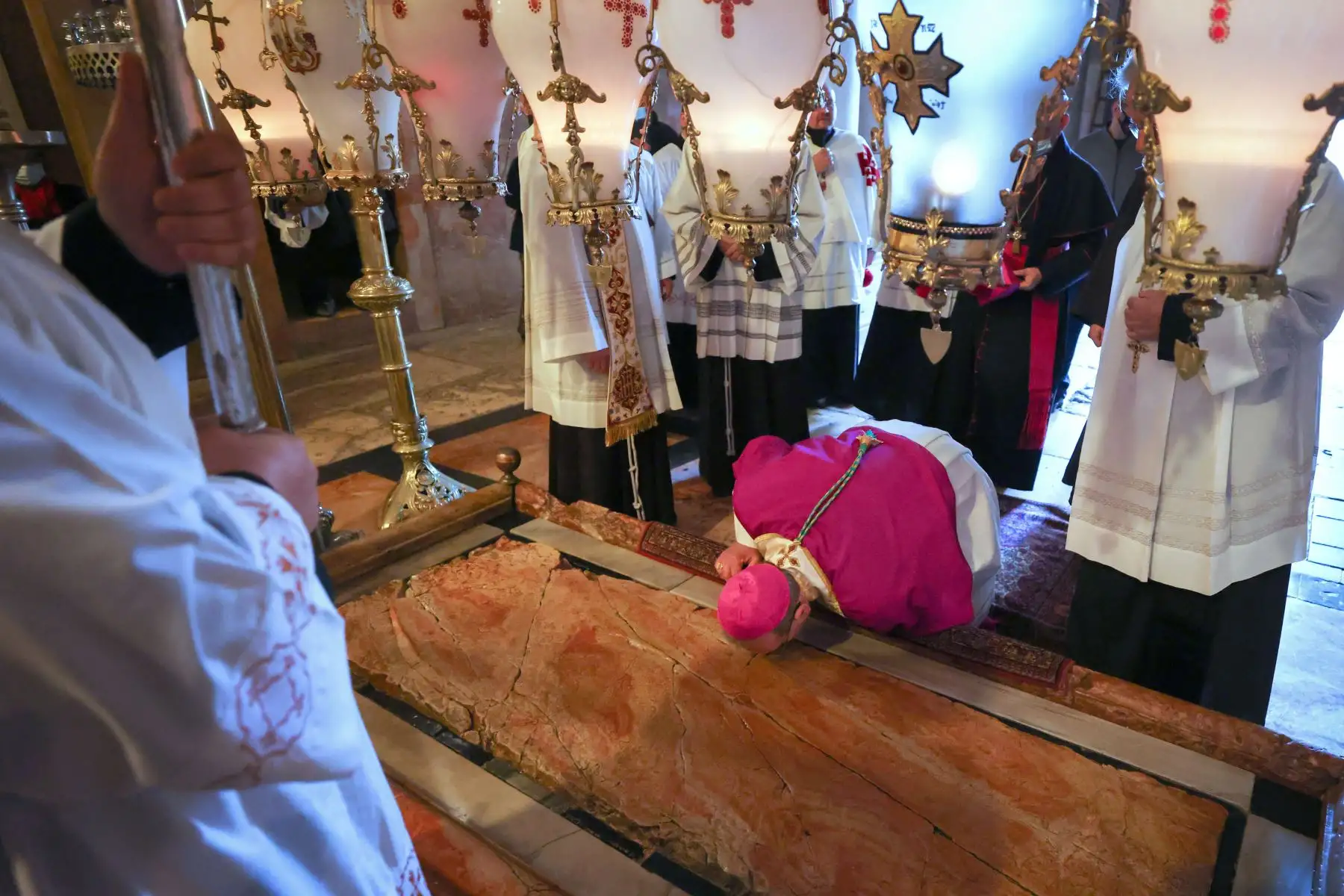 Un sacerdote católico se arrodilla para besar la Piedra de la Unción, el lugar donde se cree que fue depositado el cuerpo de Jesucristo después de ser bajado de la cruz, durante una misa de vigilia de Pascua el Sábado Santo en la Iglesia del Santo Sepulcro en Jerusalén.
Foto: AFP