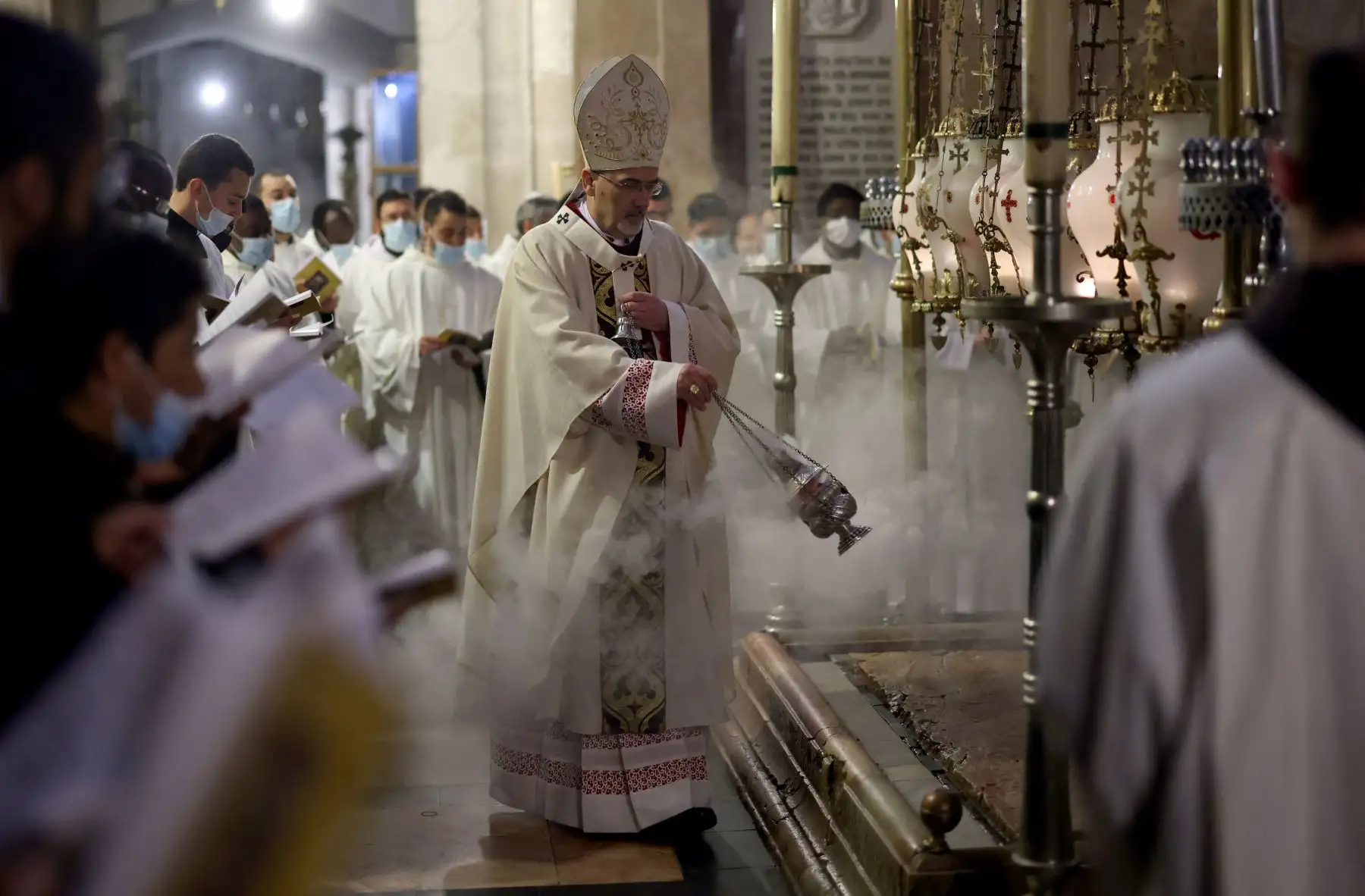 El Patriarca Latino de Jerusalén Pierbattista Pizzaballa quema incienso alrededor de la Piedra de la Unción, el lugar donde se cree que fue depositado el cuerpo de Jesucristo después de ser bajado de la cruz, durante una misa de vigilia pascual el Sábado Santo en la Iglesia del Santo. 
Foto:  AFP