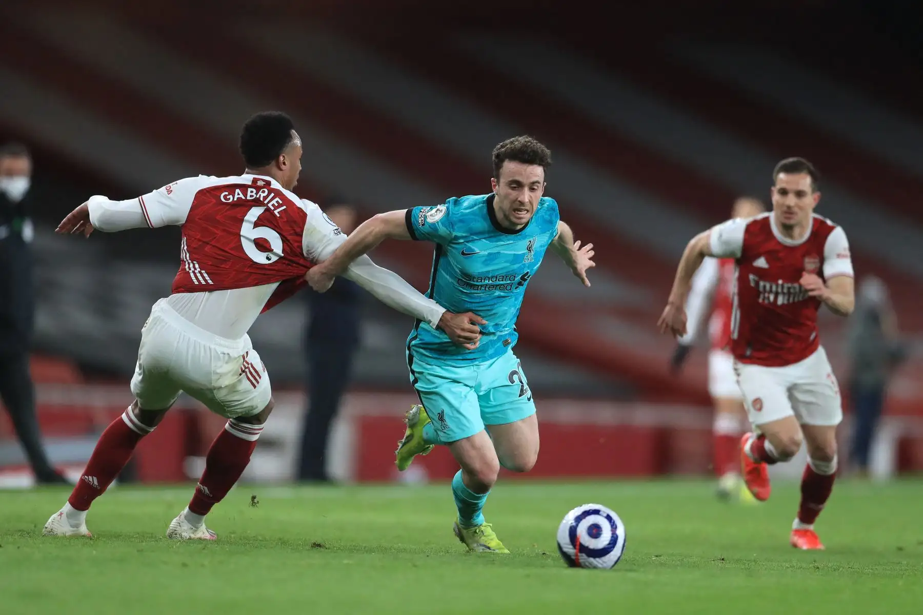 El delantero portugués del Liverpool Diogo Jota (C) pasa por delante del defensor brasileño del Arsenal Gabriel (L) durante el partido de fútbol de la Premier League inglesa entre el Arsenal y el Liverpool en el Emirates Stadium de Londres. Foto: AFP