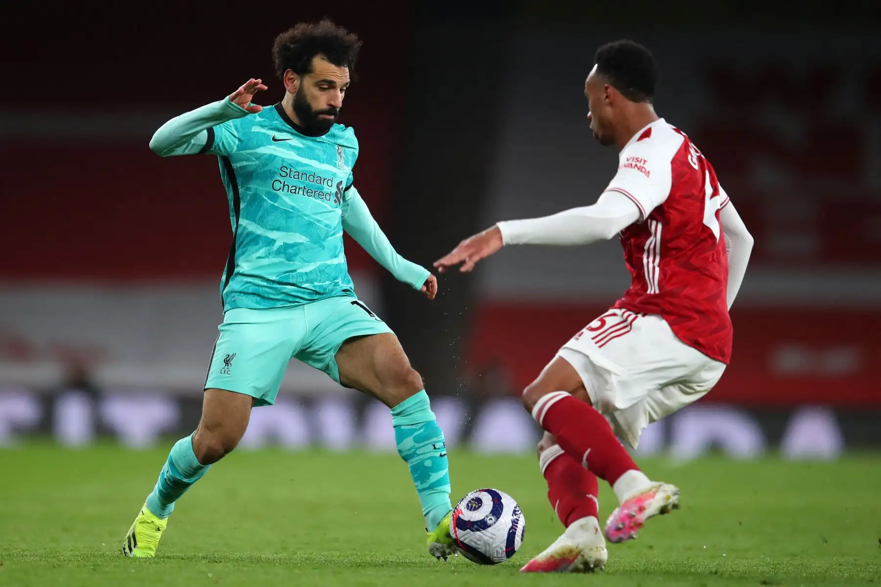 El mediocampista egipcio del Liverpool, Mohamed Salah (izq.), Corre con el balón mientras el defensor brasileño del Arsenal Gabriel se acerca durante el partido de fútbol de la Premier League inglesa entre el Arsenal y el Liverpool en el Emirates Stadium de Londres. Foto: AFP
