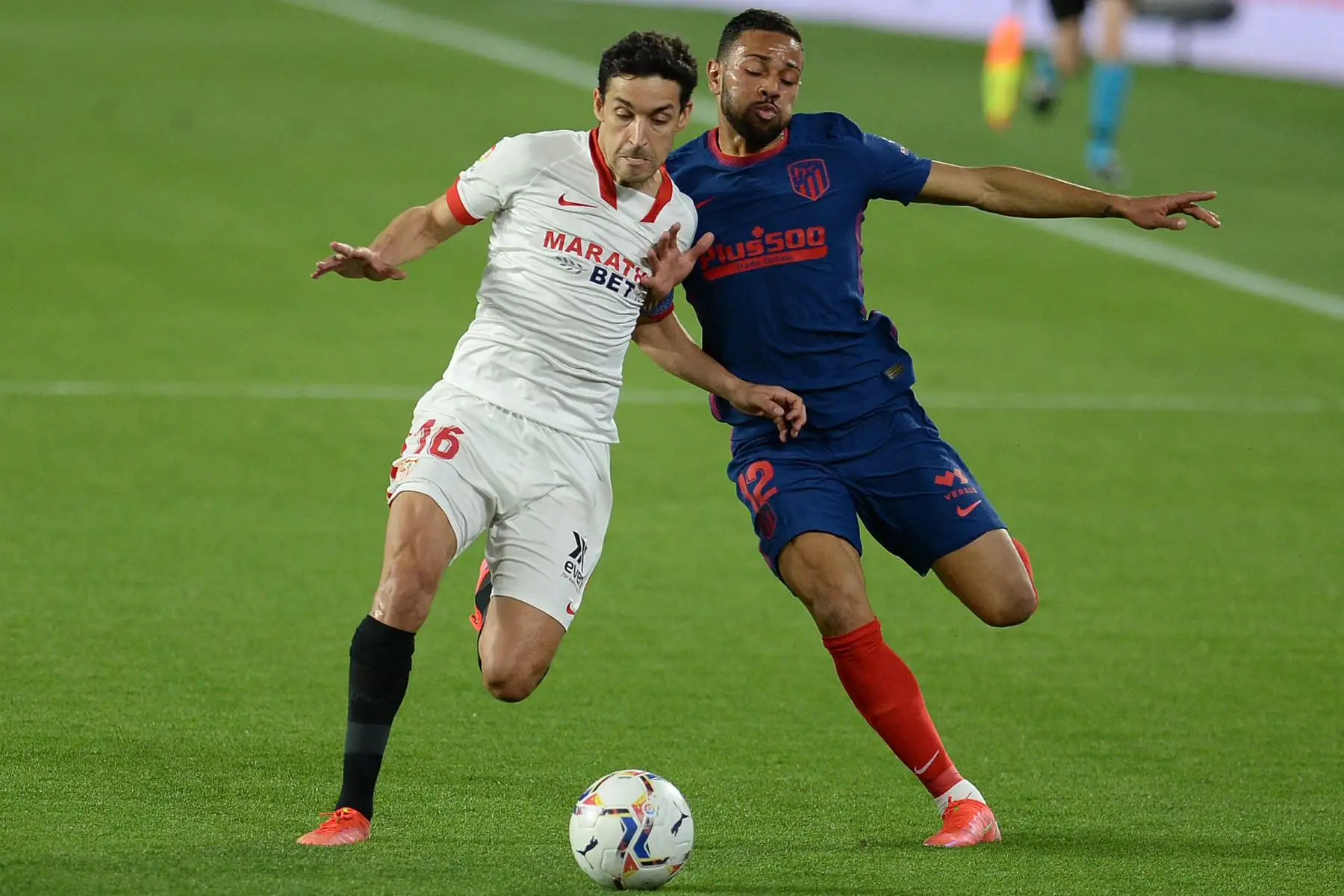 El defensor brasileño del Atlético de Madrid Renan Lodi (R) desafía al centrocampista español del Sevilla Jesús Navas durante el partido de fútbol de la Liga española entre el Sevilla FC y el Club Atlético de Madrid en el estadio Ramón Sánchez Pizjuan de Sevilla. Foto: AFP