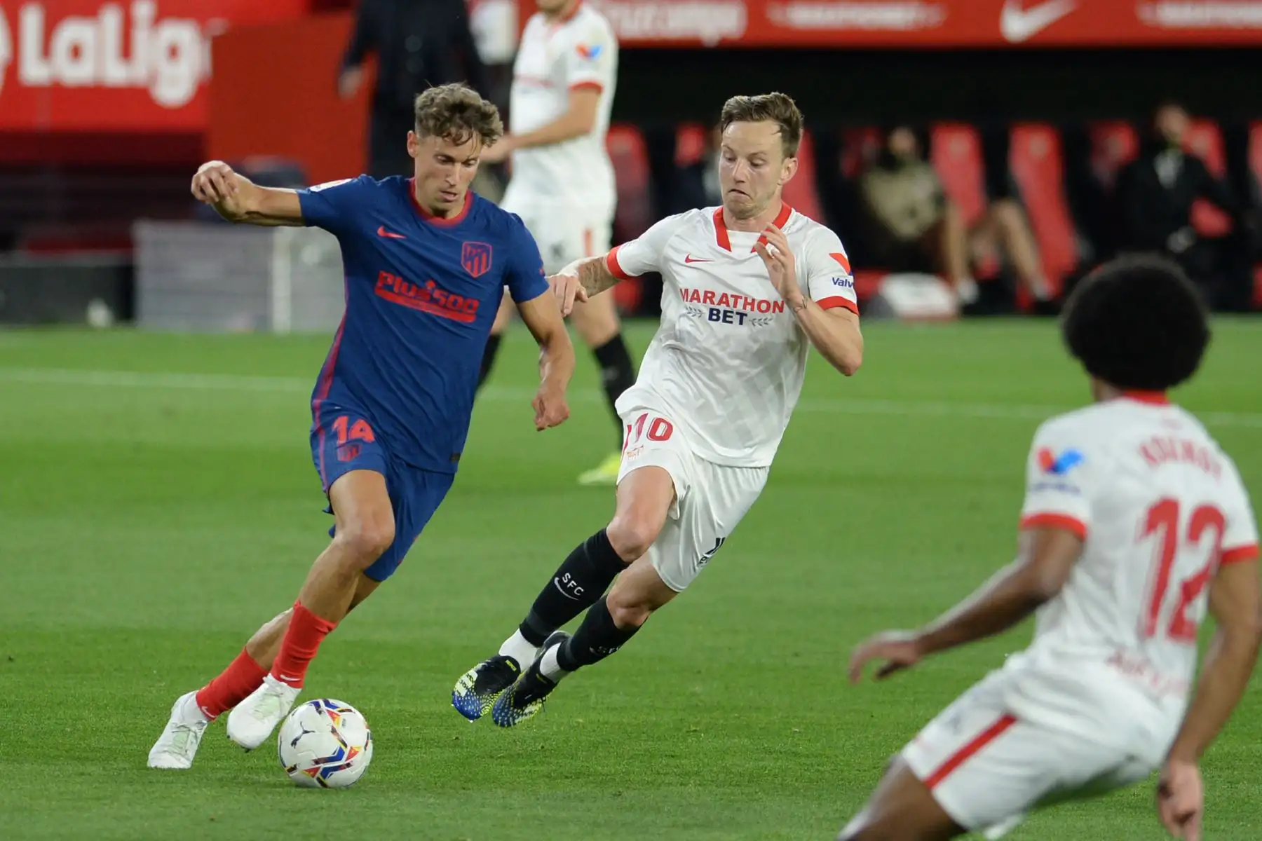 El centrocampista español del Atlético de Madrid Marcos Llorente (L) desafía al centrocampista croata del Sevilla Ivan Rakitic durante el partido de fútbol de la Liga española entre el Sevilla FC y el Club Atlético de Madrid en el estadio Ramón Sánchez Pizjuan de Sevilla. Foto: AFP