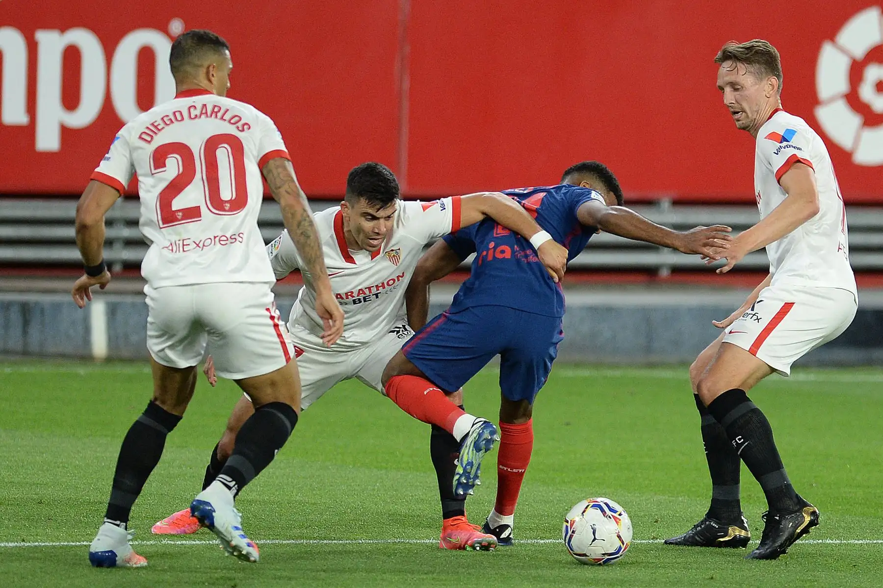 El defensor argentino del Sevilla Marcos Acuña (C-L) desafía al centrocampista francés del Atlético de Madrid Thomas Lemar (C-R) durante el partido de fútbol de la Liga española entre el Sevilla FC y el Club Atlético de Madrid en el estadio Ramón Sánchez Pizjuan de Sevilla. Foto: AFP