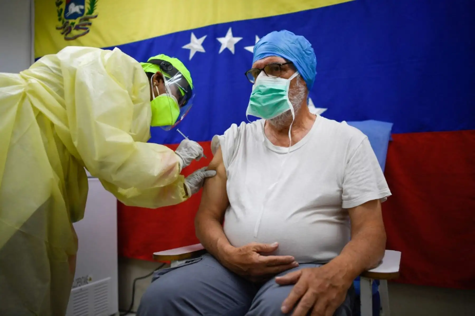 Un trabajador de salud administra una dosis de la vacuna Sputnik V contra COVID-19 a un miembro del personal del Hospital Pérez de León en el barrio de Petare, en el este de Caracas.

Foto: AFP