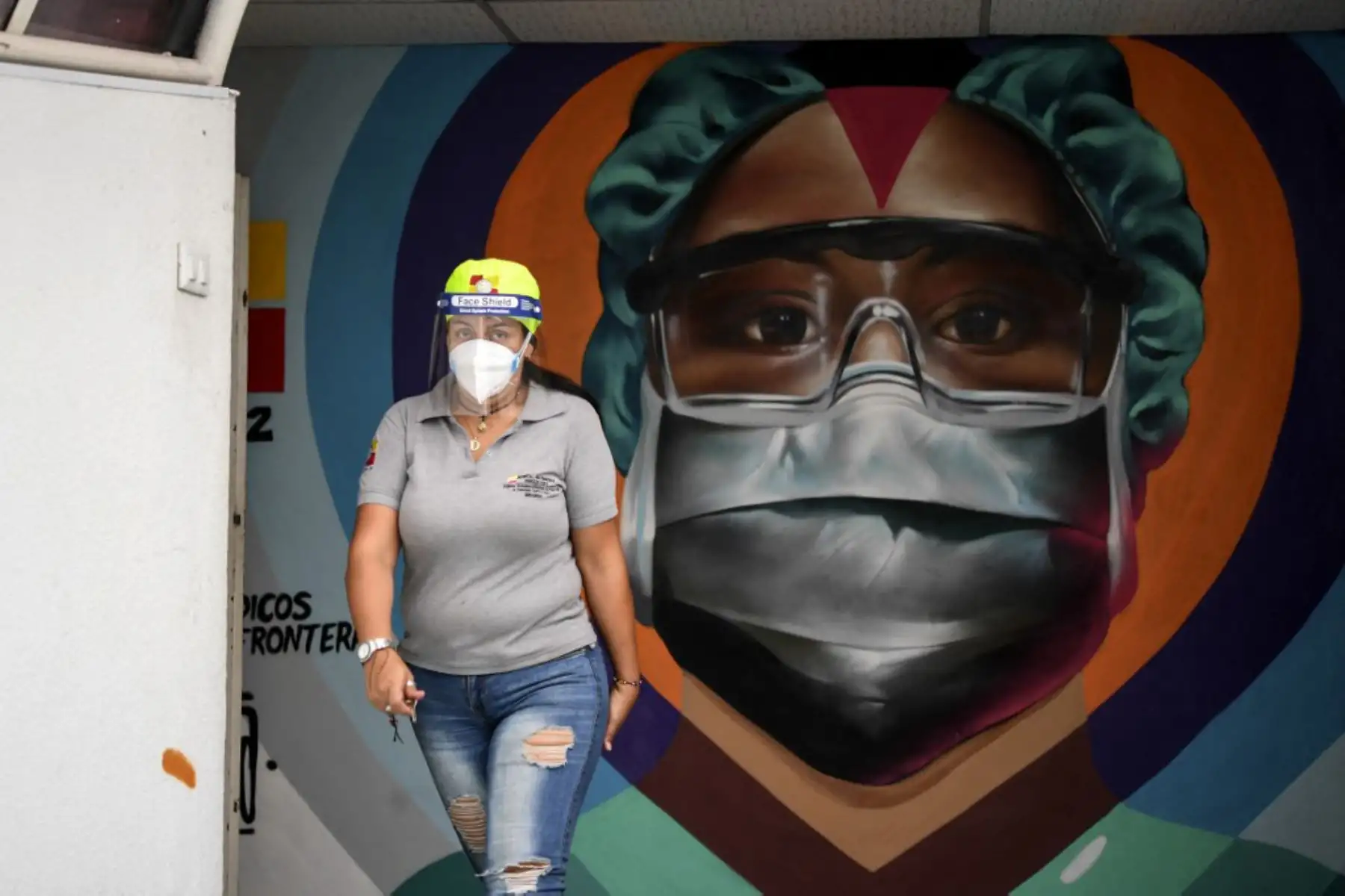 Un trabajador de la salud con máscara KN-95 y careta pasa frente a un mural pintado en homenaje a la labor que realizan los equipos médicos contra la pandemia de COVID-19 en el Hospital Estatal Ana Francisca Pérez de León de Caracas.

Foto: AFP