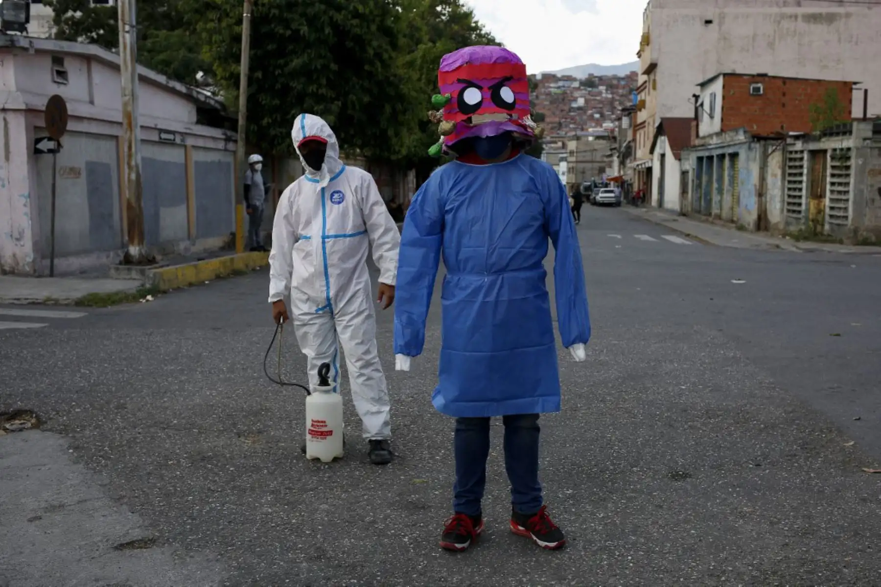 Un hombre usa una máscara que representa el coronavirus Covid-19 antes de ponerla a un maniquí y prenderle fuego durante la tradicional "quema de Judas" el día de Pascua en la plaza Venezuela.

Foto: AFP