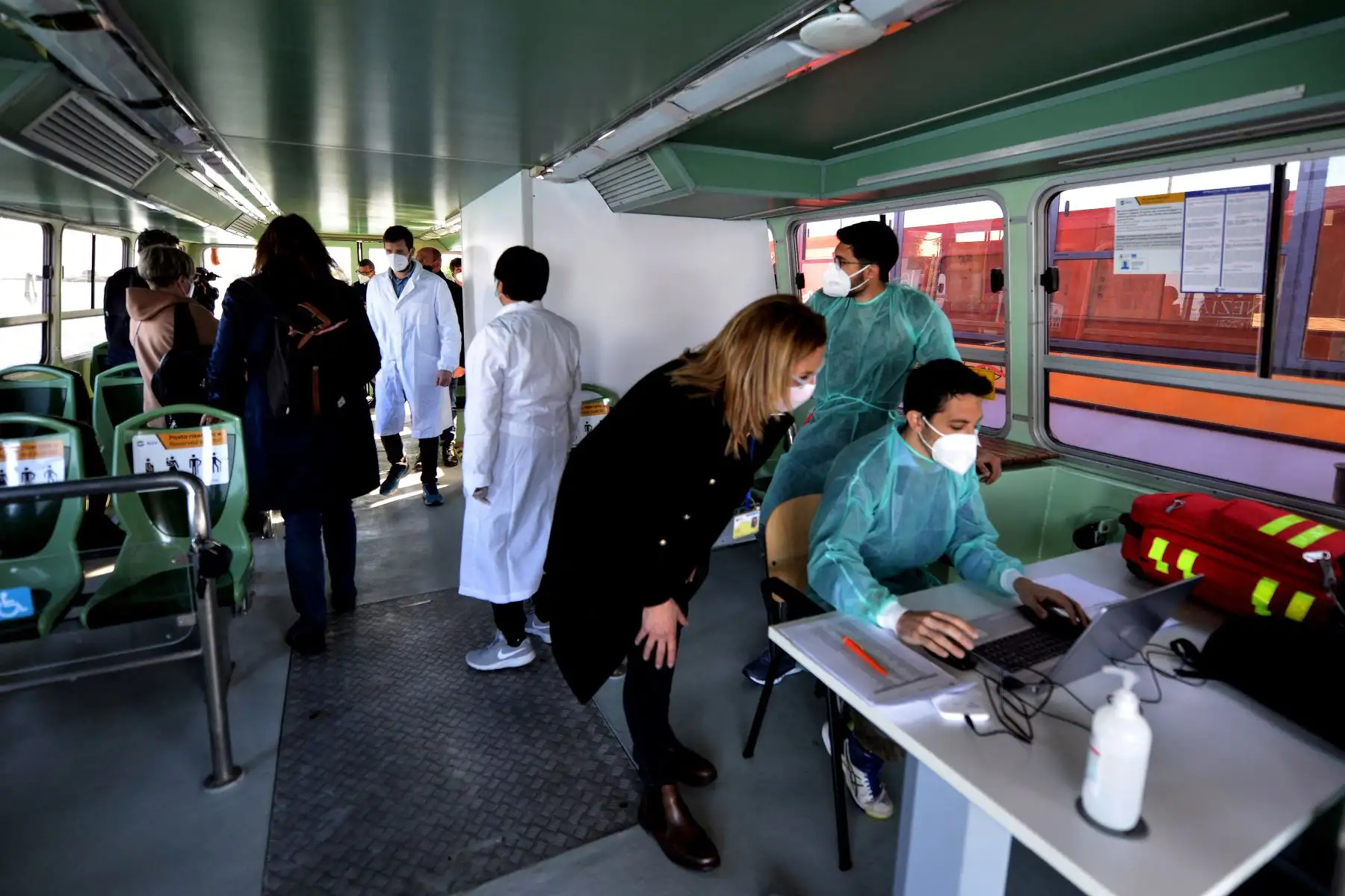 Un residente habla con trabajadores médicos antes de recibir una vacuna Covid-19 contra la enfermedad por coronavirus en un embarcación público de Venecia, Italia. Foto: AFP