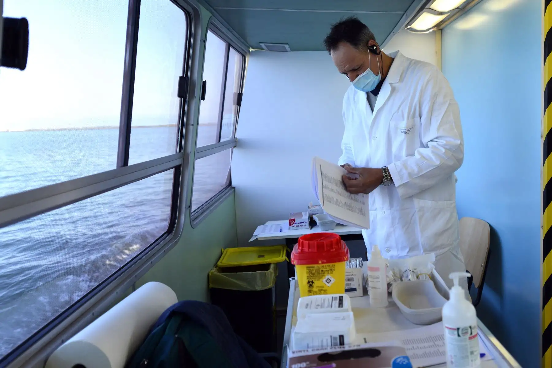 Un médico revisa los formularios en la embarcación antes de aplicar la vacuna contra el coronavirus, en Venecia, Italia. Foto: AFP