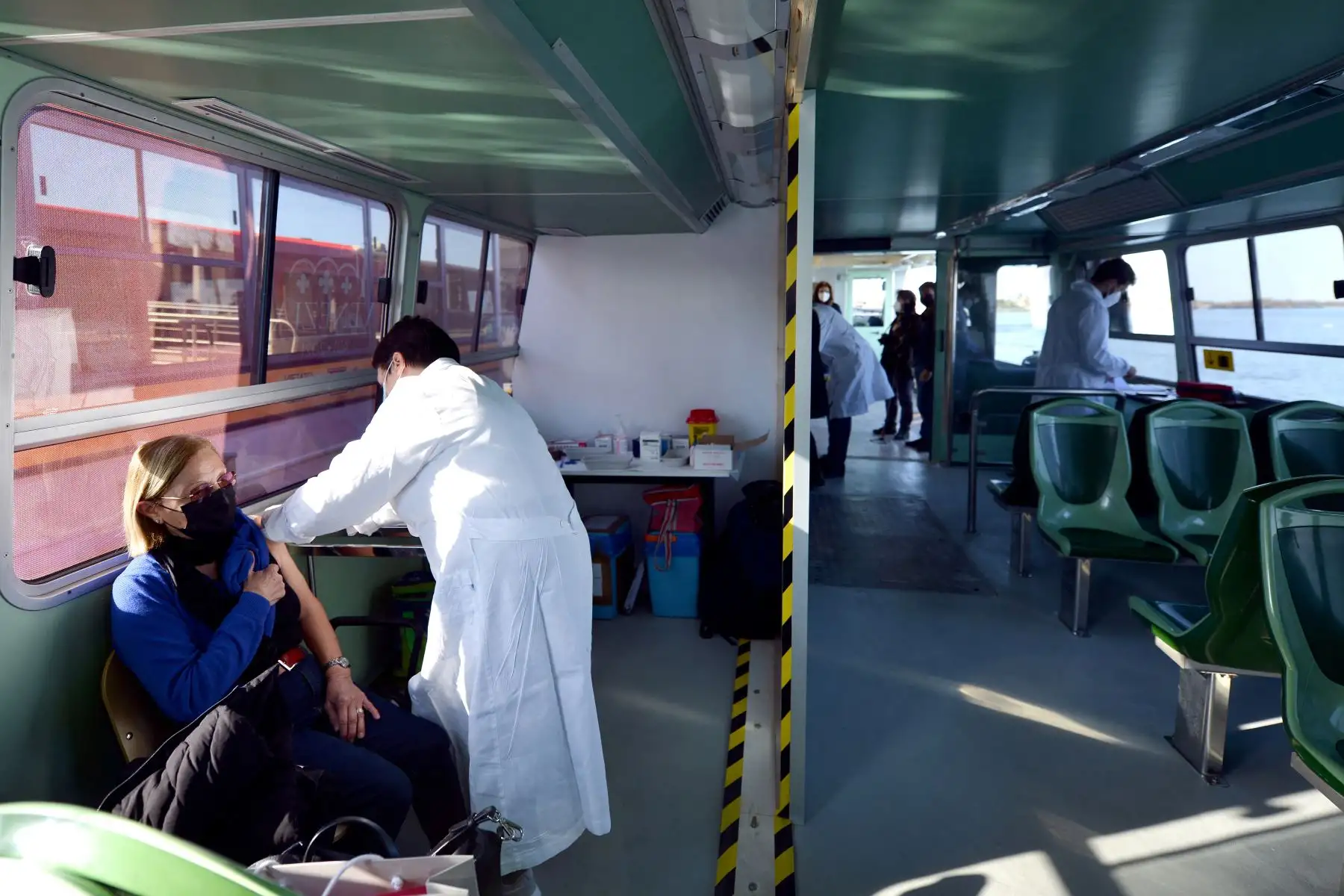 Un residente recibe una vacuna contra la enfermedad por Covid-19 a bordo de un  "Vaporetto” habilitado para la inoculación, en Venecia, Italia. Foto: AFP