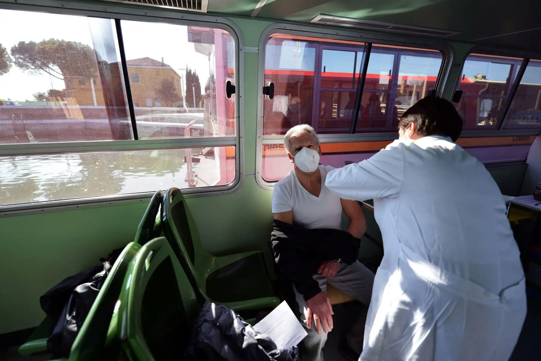 Un residente recibe una vacuna contra la enfermedad por Covid-19 a bordo de un  "Vaporetto” habilitado para la inoculación, en Venecia, Italia. Foto: AFP