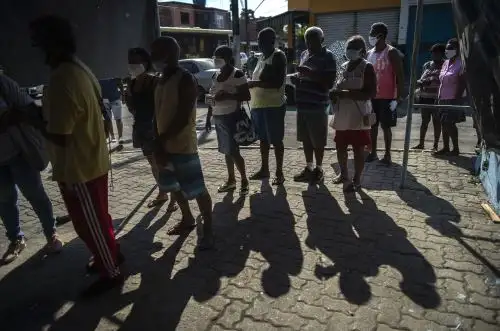 Personas con mascarillas hacen cola para recibir una dosis de la vacuna de covid-19 en un centro de vacunación en la plaza Cangulo, barrio Saracuruna, en Duque de Caxias, estado de Río de Janeiro, Brasil. Foto: AFP