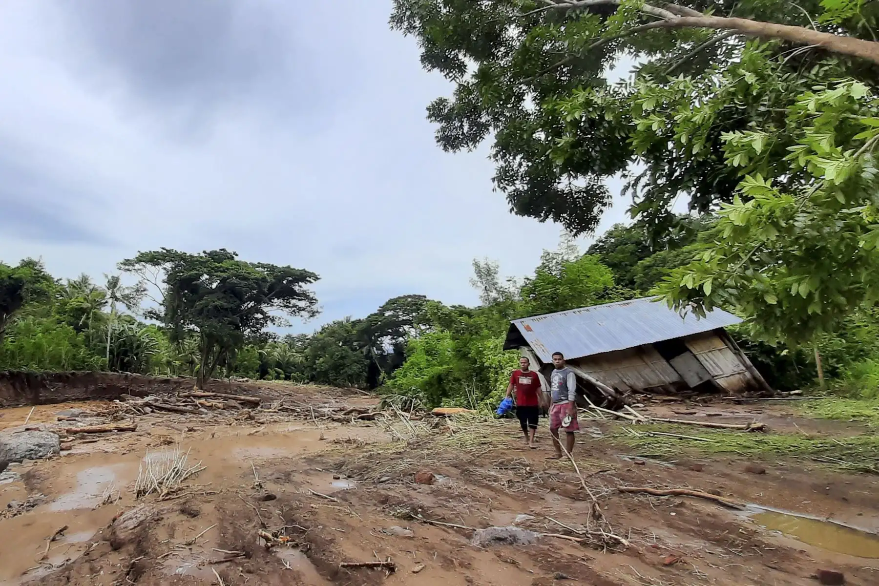 Dos hombres observan las viviendas dañadas después de una inundación repentina en la aldea de Waiwerang, East Flores, ya que al menos 157 personas murieron en Indonesia y el país vecino Timor Oriental. Foto: AFP