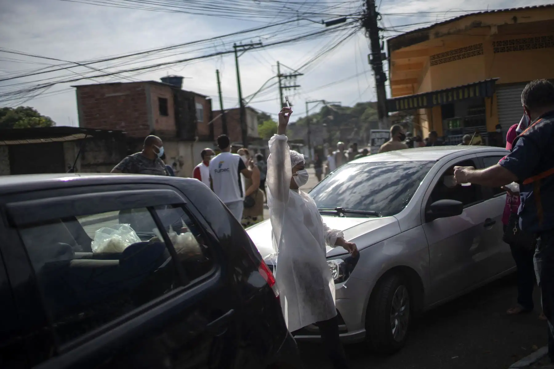 Un trabajador de salud sostiene una jeringa con una dosis de la vacuna COVID-19 en un centro de vacunación en la plaza Cangulo, en Duque de Caxias, estado de Río de Janeiro, Brasil, el 30 de marzo de 2021. Foto: AFP