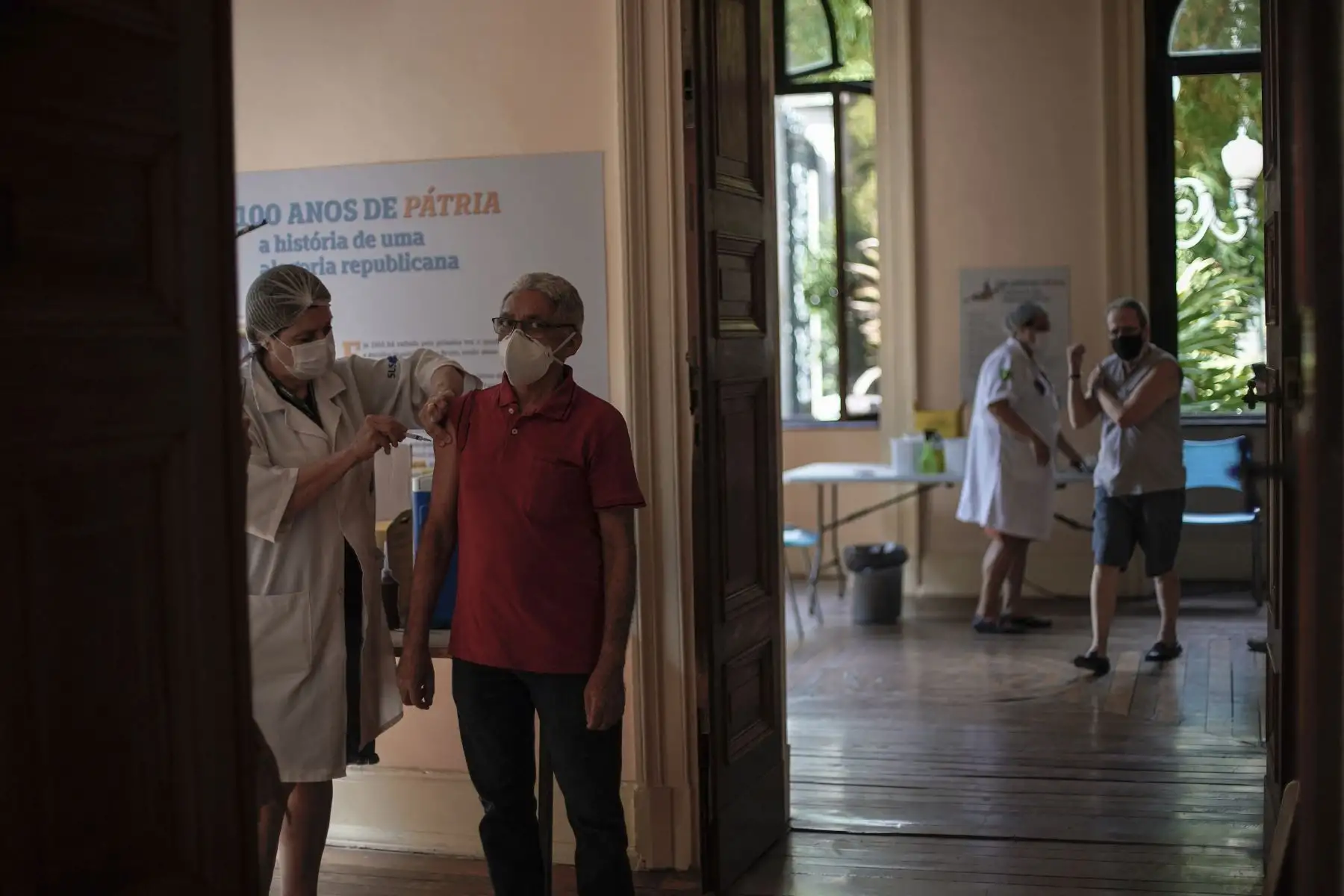 Dos hombres son inoculados contra el nuevo coronavirus con la vacuna Sinovac CoronaVac de China producida por Butantan, el mayor productor de vacunas de Brasil, en un centro de vacunación instalado en el Palacio de Catete, en Río de Janeiro, el 31 de marzo de 2021. Foto: AFP
