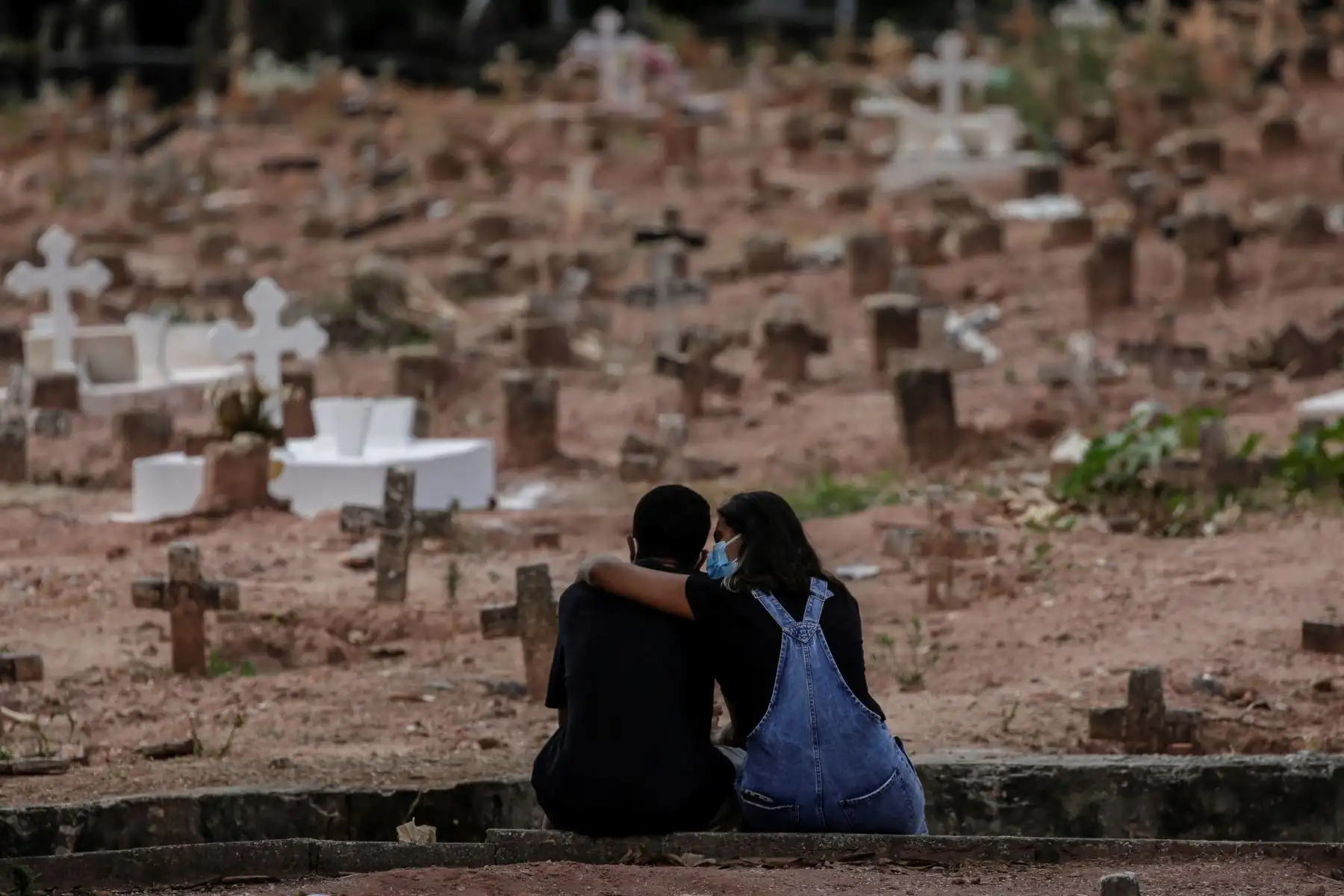 Una pareja llora a una mujer víctima de la COVID-19 que fue sepultada el 6 de abril del 2021 en un cementerio de Río de Janeiro, en Brasil.