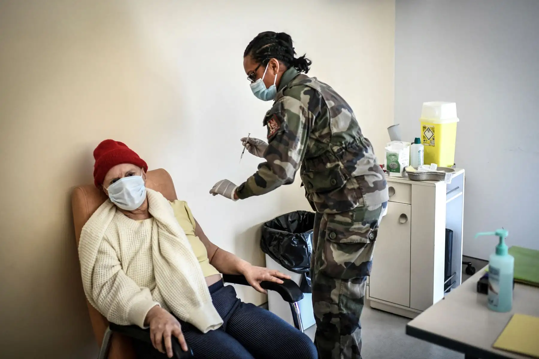 Una mujer se prepara para recibir una dosis de la vacuna Pfizer-BioNTech contra el Covid-19 en el hospital militar Begin en Saint-Mande, al este de París, el 07 de abril del 2021. Foto: AFP