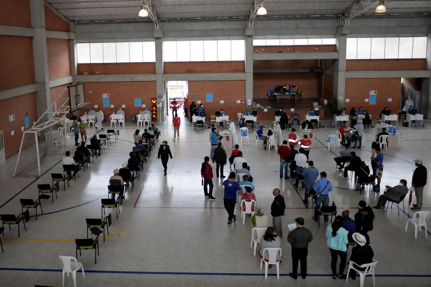 La gente espera ser inoculada con la vacuna Oxford AstraZeneca contra COVID-19 en medio de la pandemia del nuevo coronavirus, en Bogotá el 5 de abril de 2021. Foto: AFP