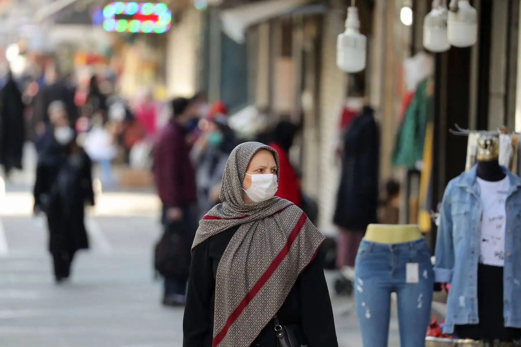 Los iraníes caminan con máscaras faciales por las calles de la capital, Teherán, en medio de la pandemia del coronavirus. Foto: AFP