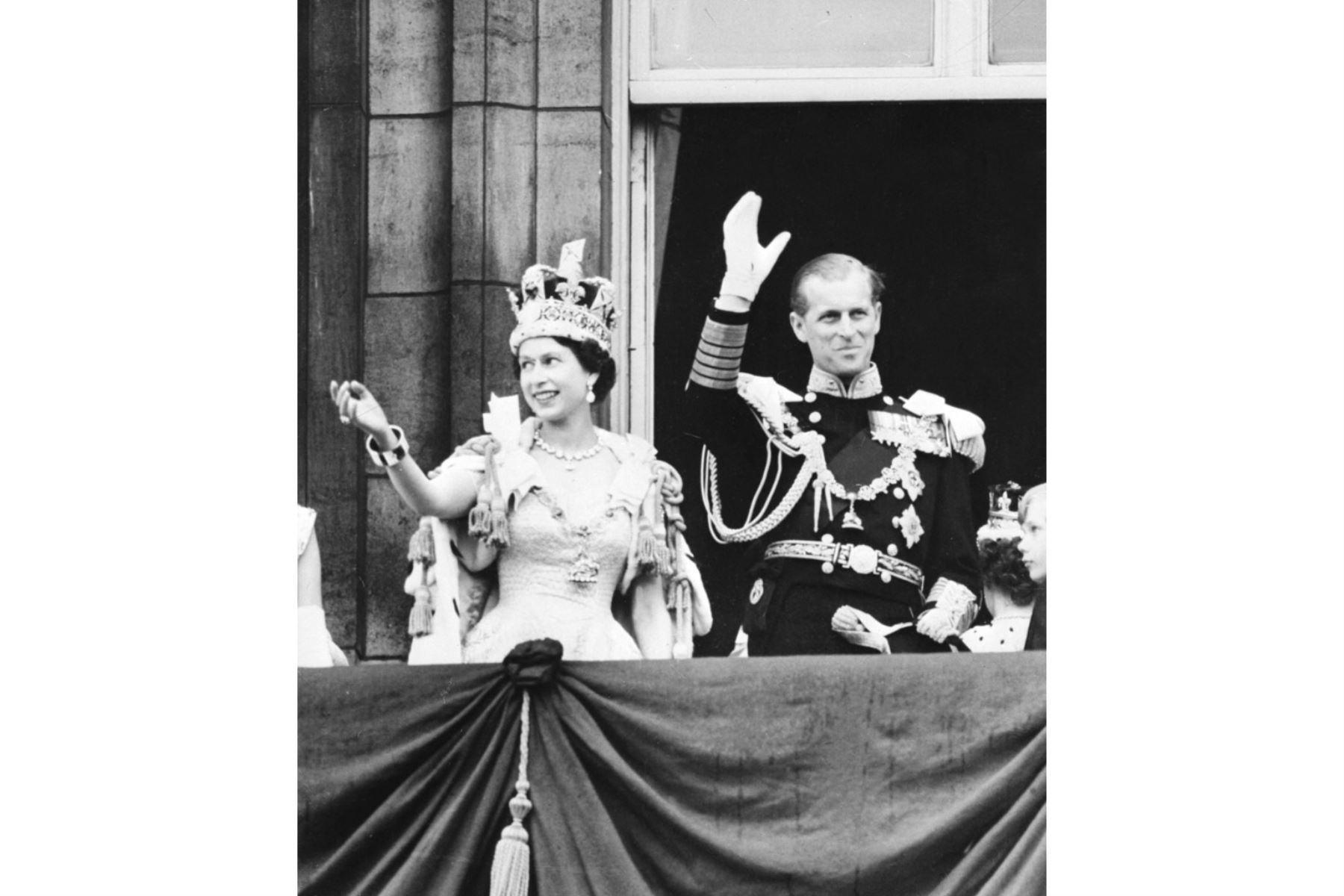La reina Isabel II de Gran Bretaña (izquierda) acompañada por el príncipe Felipe de Gran Bretaña, duque de Edimburgo (derecha) saluda a la multitud, 2 de junio de 1953 después de ser coronada en la Abadía de Westminter en Londres. Foto: AFP