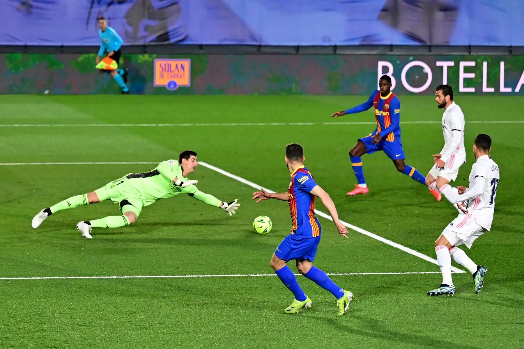El portero belga del Real Madrid Thibaut Courtois (L) se zambulle contra el balón durante el partido de fútbol de la Liga española "El Clásico" entre el Real Madrid CF y el FC Barcelona en el estadio Alfredo di Stefano de Valdebebas, en las afueras de Madrid. Foto: Difusión