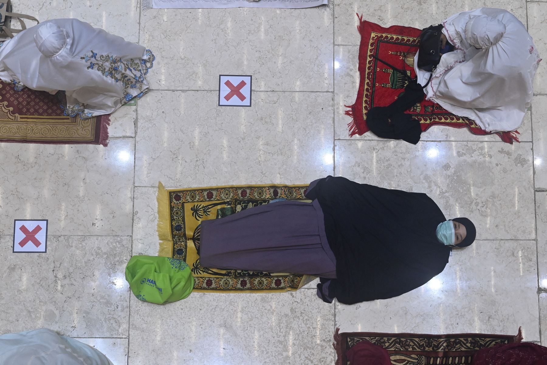 Una mujer descansa antes de las oraciones nocturnas el primer día de Ramadán en la gran mezquita Istiqlal en Yakarta el 12 de abril de 2021. Foto: AFP