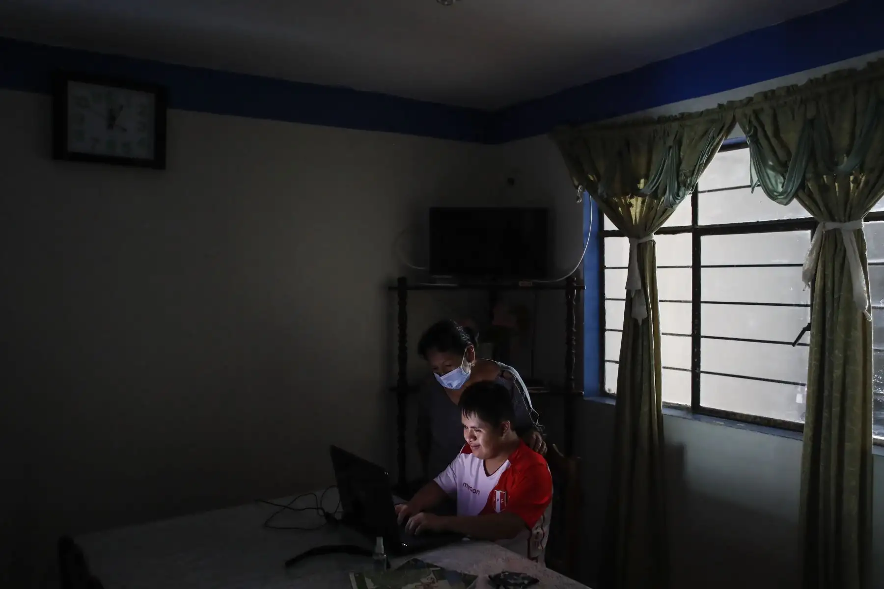 Ronny Flores enseña a su madre algunos videos de sus jugadores favoritos en Youtube. Foto: ANDINA/Renato Pajuelo