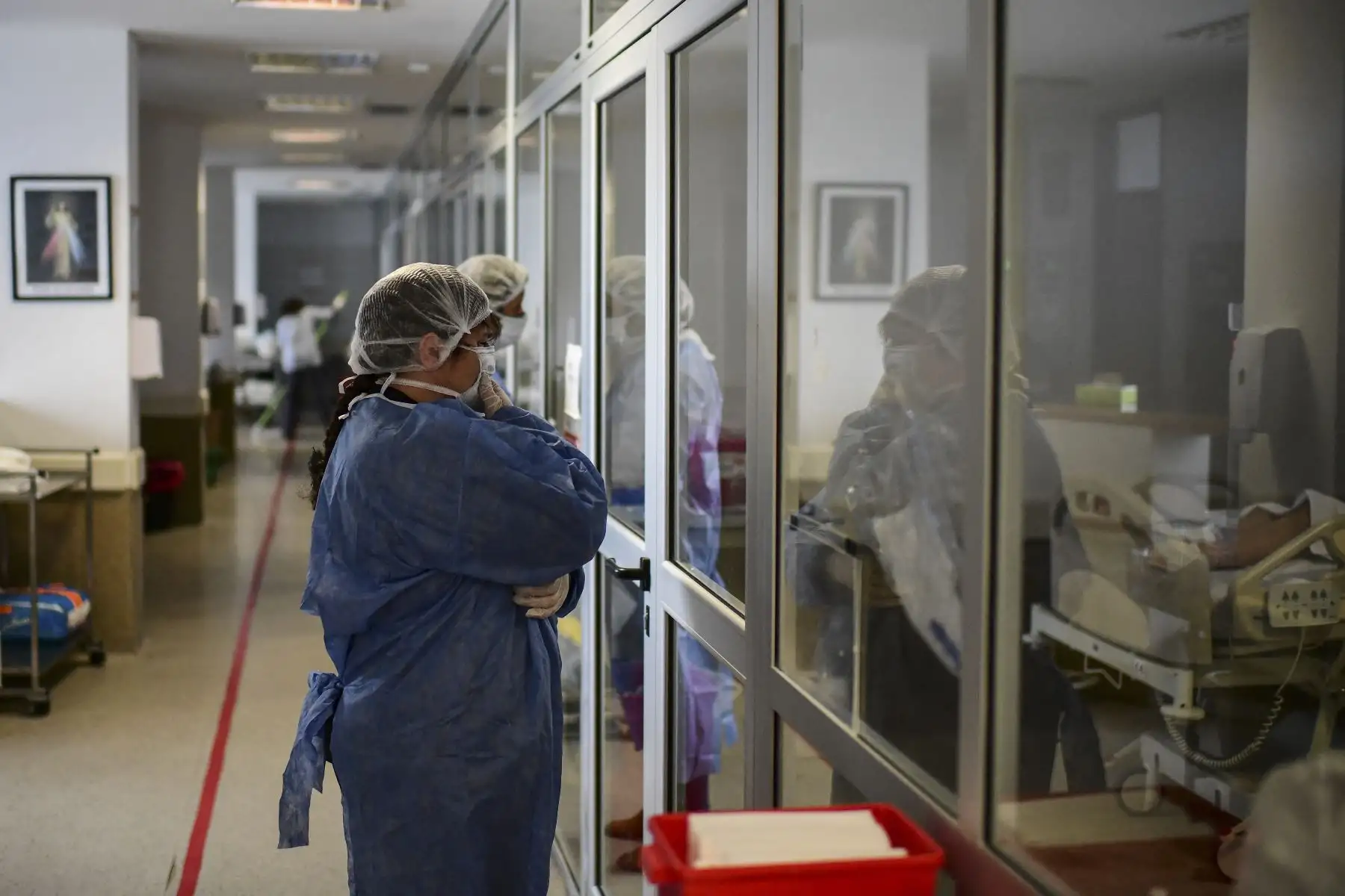 Una mujer reza mientras visita a un familiar infectado con COVID-19 en la Unidad de Cuidados Intensivos del Hospital El Cruce - Dr. Nestor Kirchner en Florencio Varela, Argentina el 13 de abril de 2021. Foto: AFP