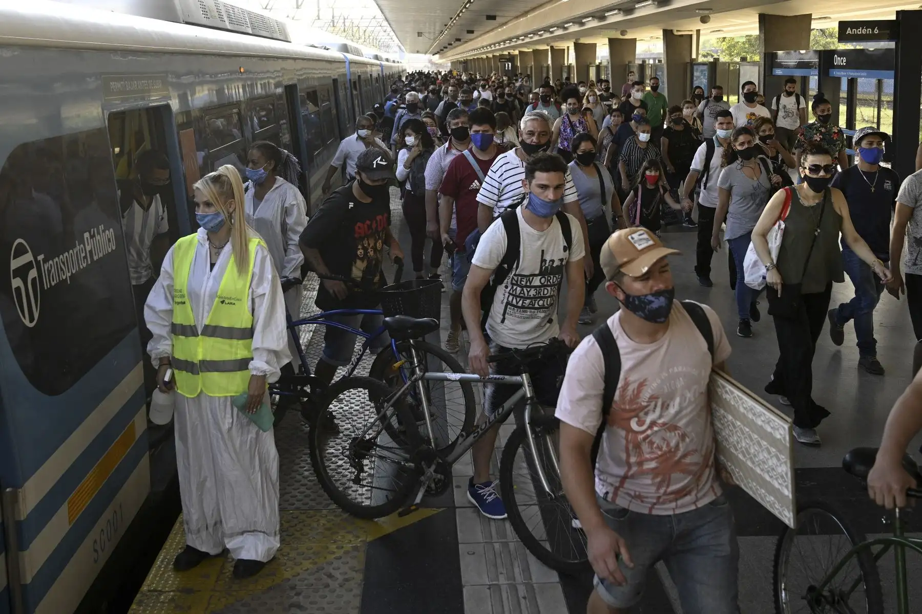 Una trabajadora espera para desinfectar la cabina de un tren de cercanías mientras los pasajeros descienden en la estación Once en Buenos Aires, el 7 de abril de 2021. Foto: AFP
