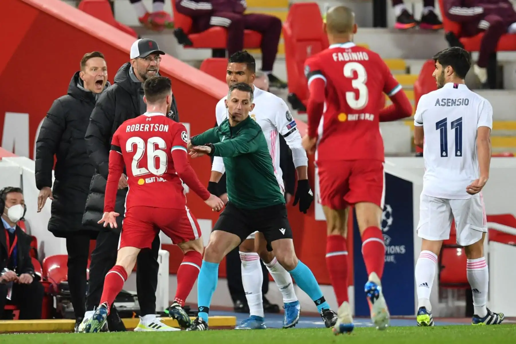 El árbitro Bjorn Kuipers (C) mantiene a raya al defensor escocés del Liverpool Andrew Robertson (L) durante un altercado durante los cuartos de final de la Liga de Campeones de la UEFA del segundo partido de fútbol entre el Liverpool y el Real Madrid en Anfield en Liverpool.
Foto: AFP