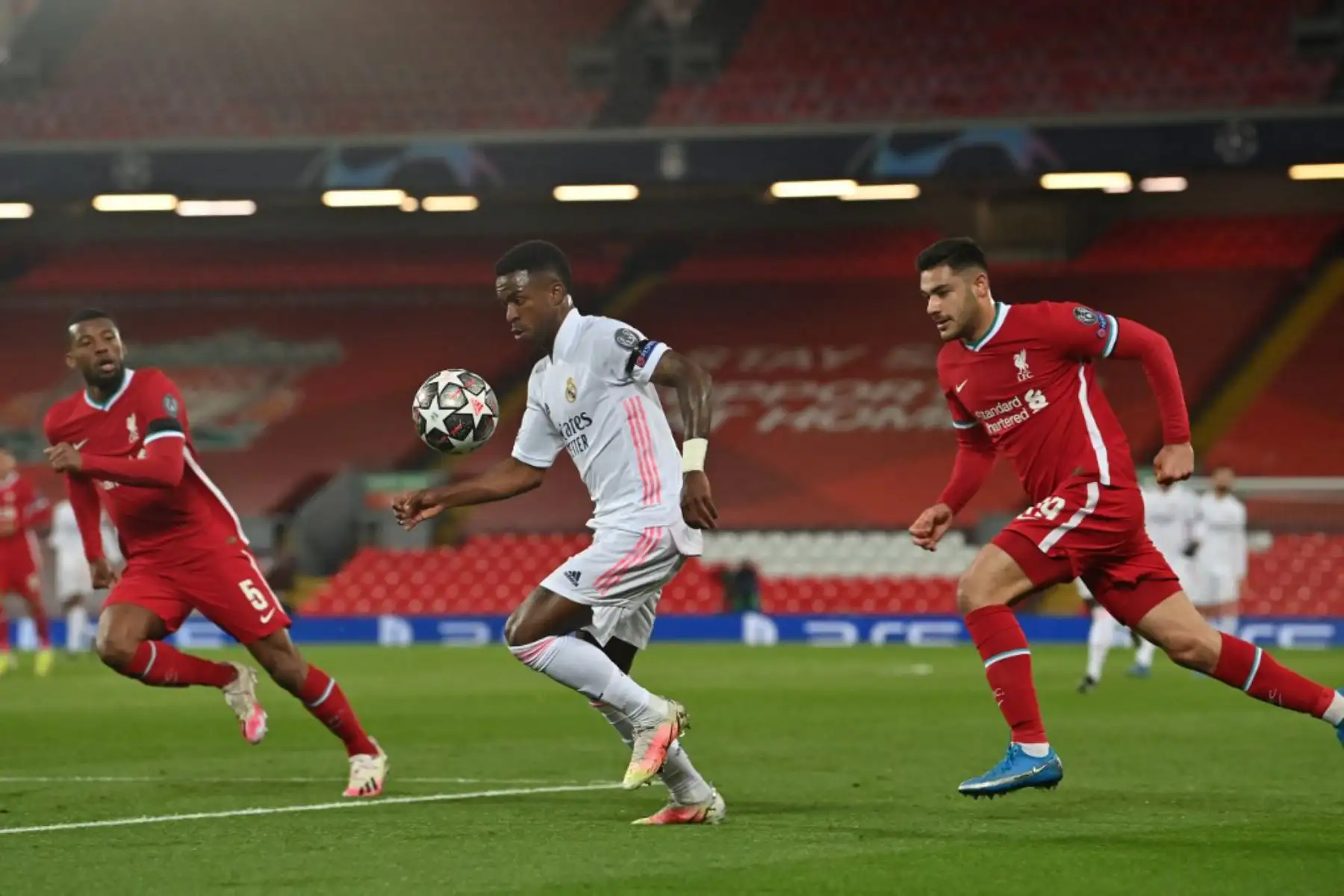 El delantero brasileño del Real Madrid Vinicius Junior (C) compite con el centrocampista holandés del Liverpool Georginio Wijnaldum (L) y el defensor turco del Liverpool Ozan Kabak durante los cuartos de final de la Liga de Campeones de la UEFA en el segundo tramo del partido de fútbol entre el Liverpool y el Real Madrid en Anfield en Liverpool.

Foto: AFP