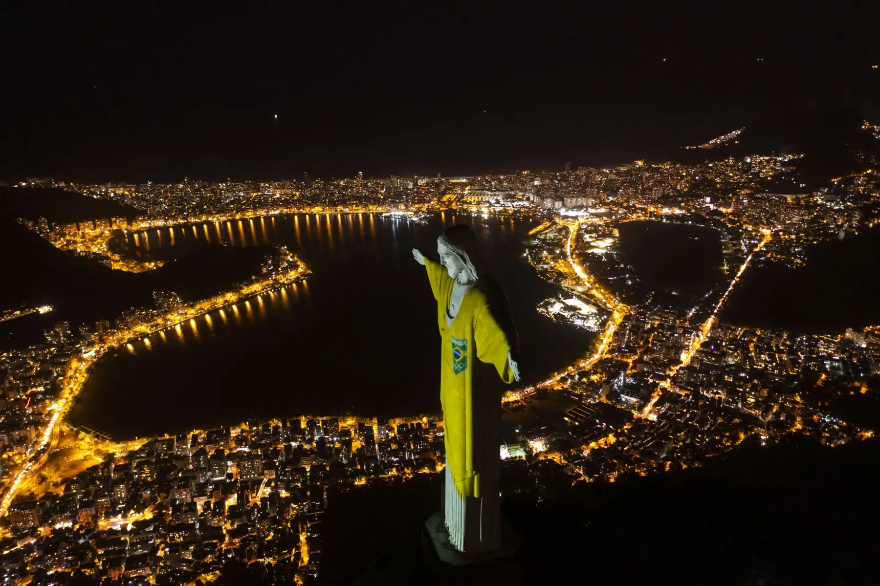 Vista aérea de la estatua del Cristo Redentor iluminada con los colores de la bandera brasileña para marcar los 100 días hasta los Juegos Olímpicos de Tokio 2020 en Río de Janeiro, Brasil.
Foto: AFP