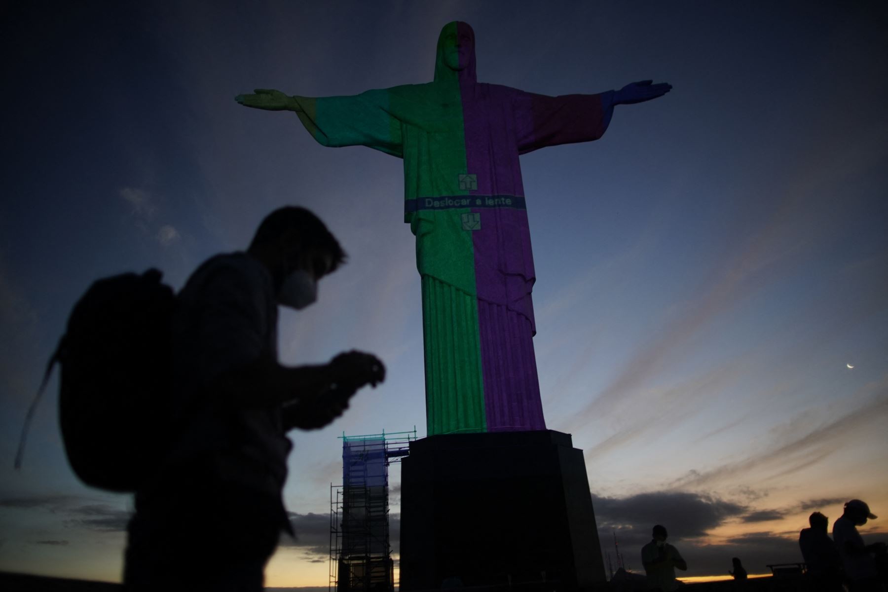 La estatua del Cristo Redentor se ve preparada para ser iluminada con los colores de la bandera brasileña y flechas olímpicas para marcar los 100 días hasta los Juegos Olímpicos de Tokio 2020 en Río de Janeiro, Brasil.
Foto: AFP