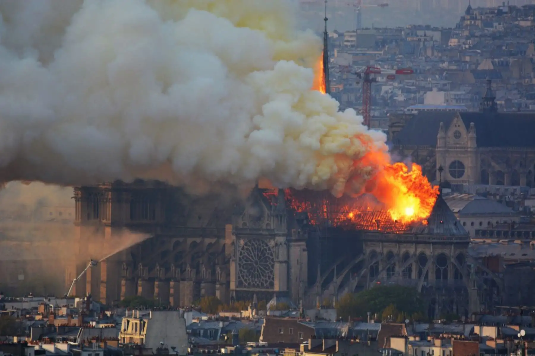 Vista desde el otro lado del río Sena, el humo y las llamas se elevan durante un incendio en la histórica catedral de Notre-Dame en el centro de París.

Foto: AFP