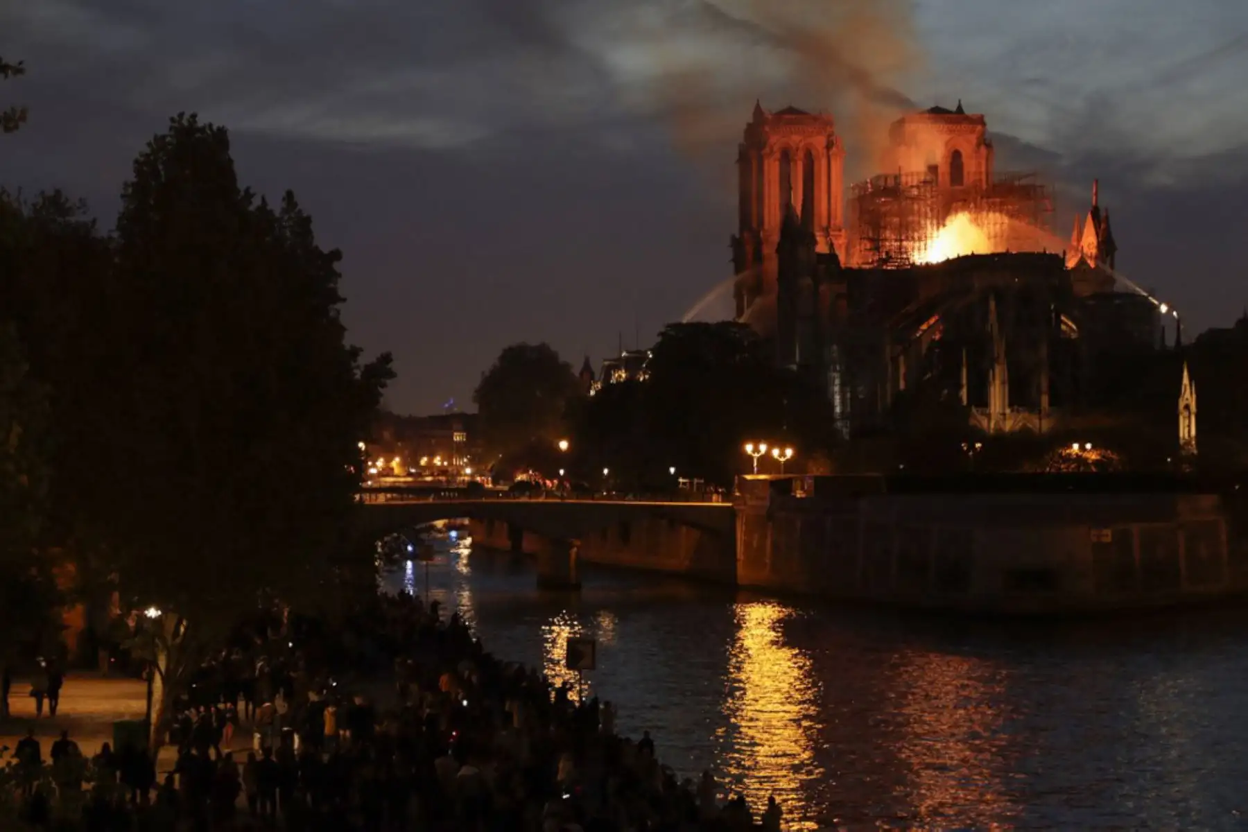 Los bomberos apagan las llamas que ondean desde el techo de la catedral de Notre-Dame en París.

Foto: AFP