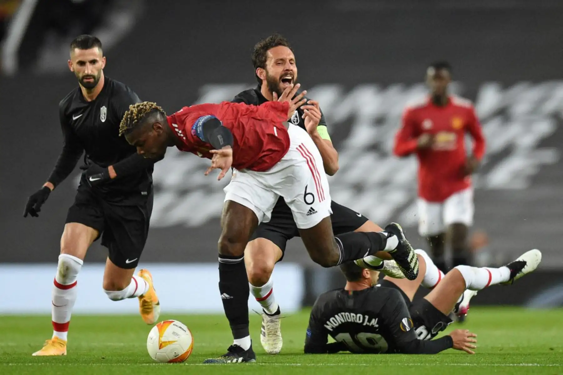 El centrocampista francés del Manchester United Paul Pogba (C) está amonestado por esta falta durante los cuartos de final de la UEFA Europa League, partido de vuelta entre el Manchester United y el Granada.

Foto:AFP
